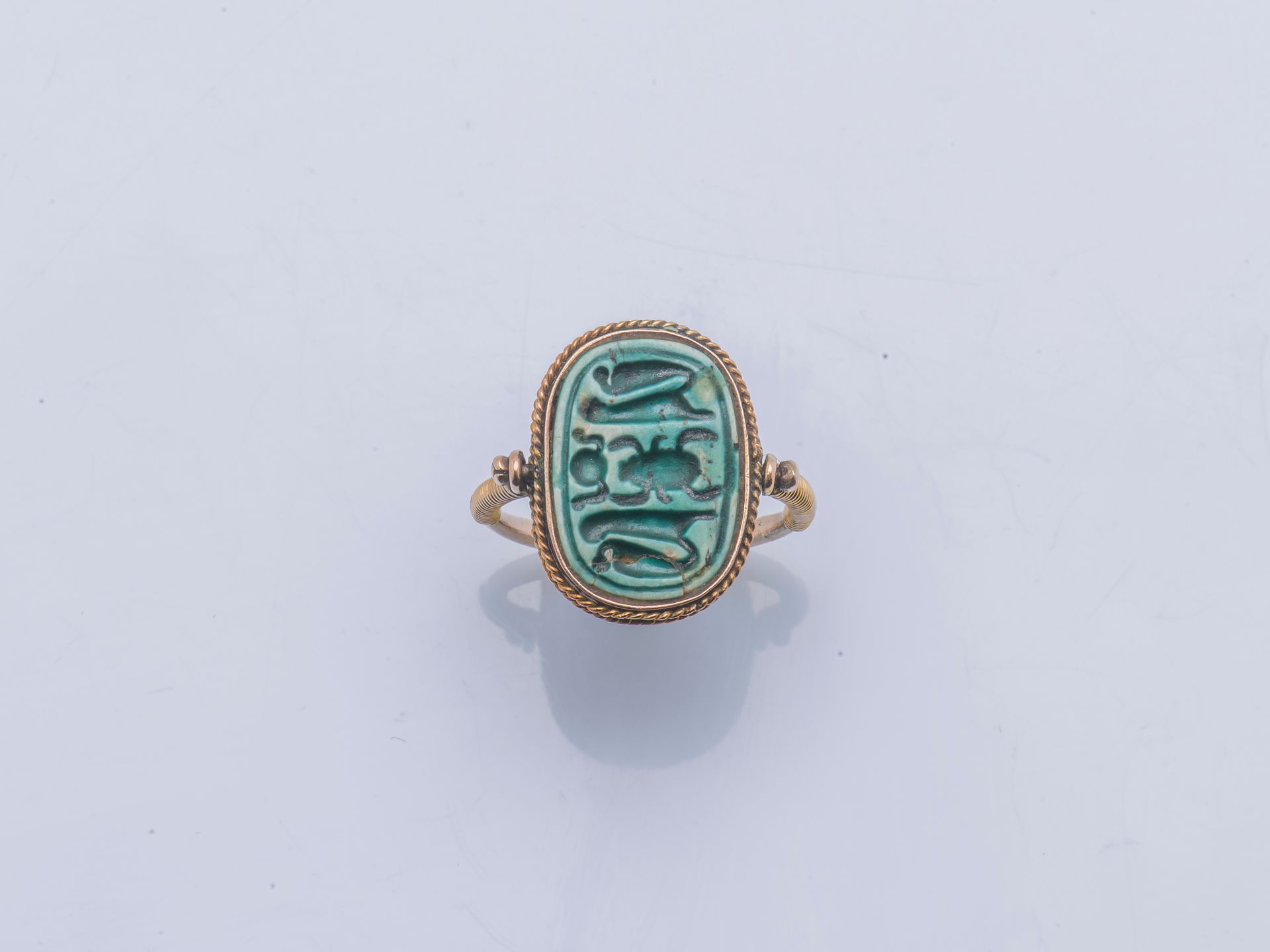 Null 14克拉（585千分之一）黄金的仿古风格戒指，在转轴上镶嵌有象形文字装饰的蓝色陶器，肩部线圈。

手指尺寸 : 47 / 48 毛重 : 3,8 g