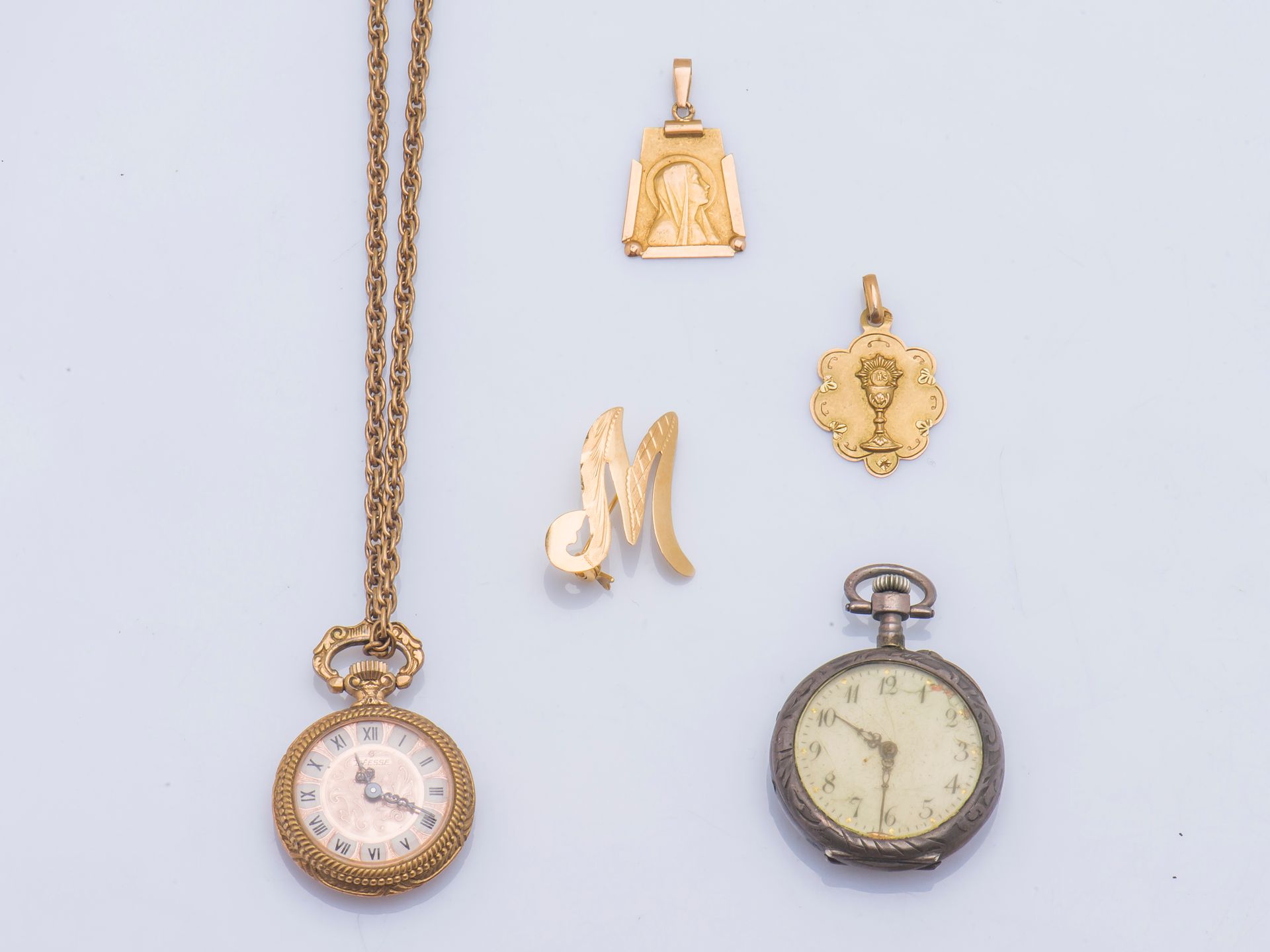 Null 
18克拉（750千分之一）黄金拍品，包括一个形成字母M的胸针，一个描绘圣母的吊坠，以及一个描绘圣杯的多叶吊坠。




重量 : 3,7 g



&hellip;