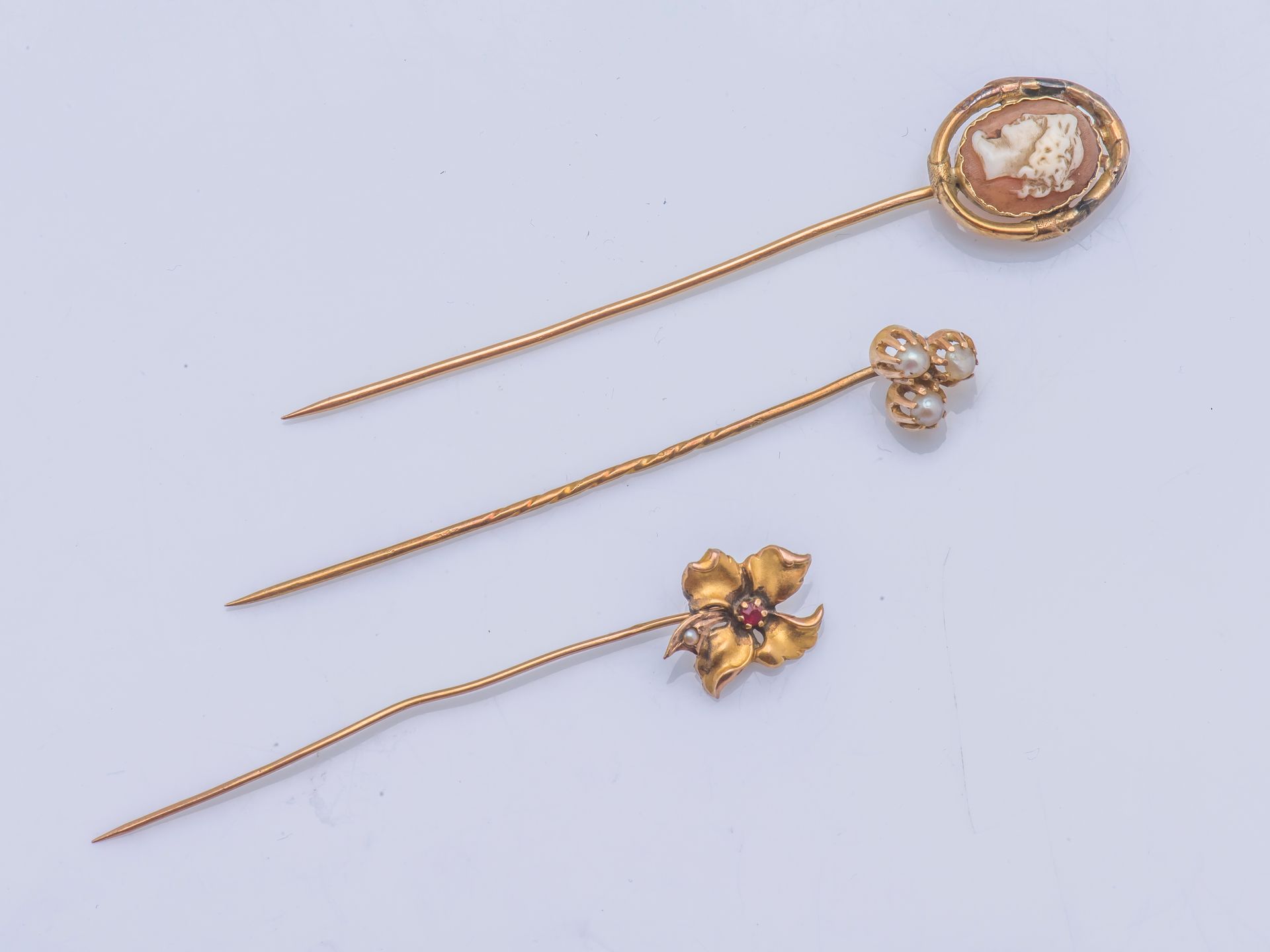 Null 一套三件18克拉（750千分之一）黄金领带夹，其中一件有一个贝壳浮雕，显示一个女性的轮廓，第二件有一朵嵌有小红宝石和一颗珍珠的镂空花，第三件有三颗小珍&hellip;
