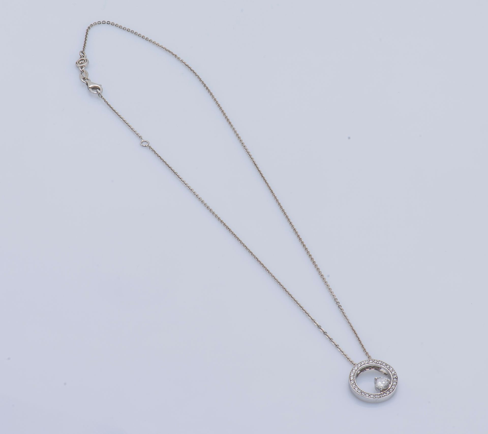 Null 银质项链（925 ‰）由一条链子和一个镶有白色宝石的圆形吊坠组成，其中一颗较大。

项链尺寸：20厘米 毛重：5克