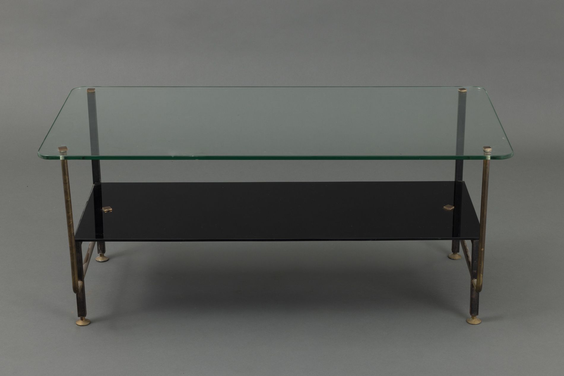 Null 双层玻璃顶的咖啡桌，黑色漆面金属和黄铜结构，黑色染色的顶部。 
1950年代的作品。 
尺寸：40 x 90 x 45厘米 
顶部有划痕