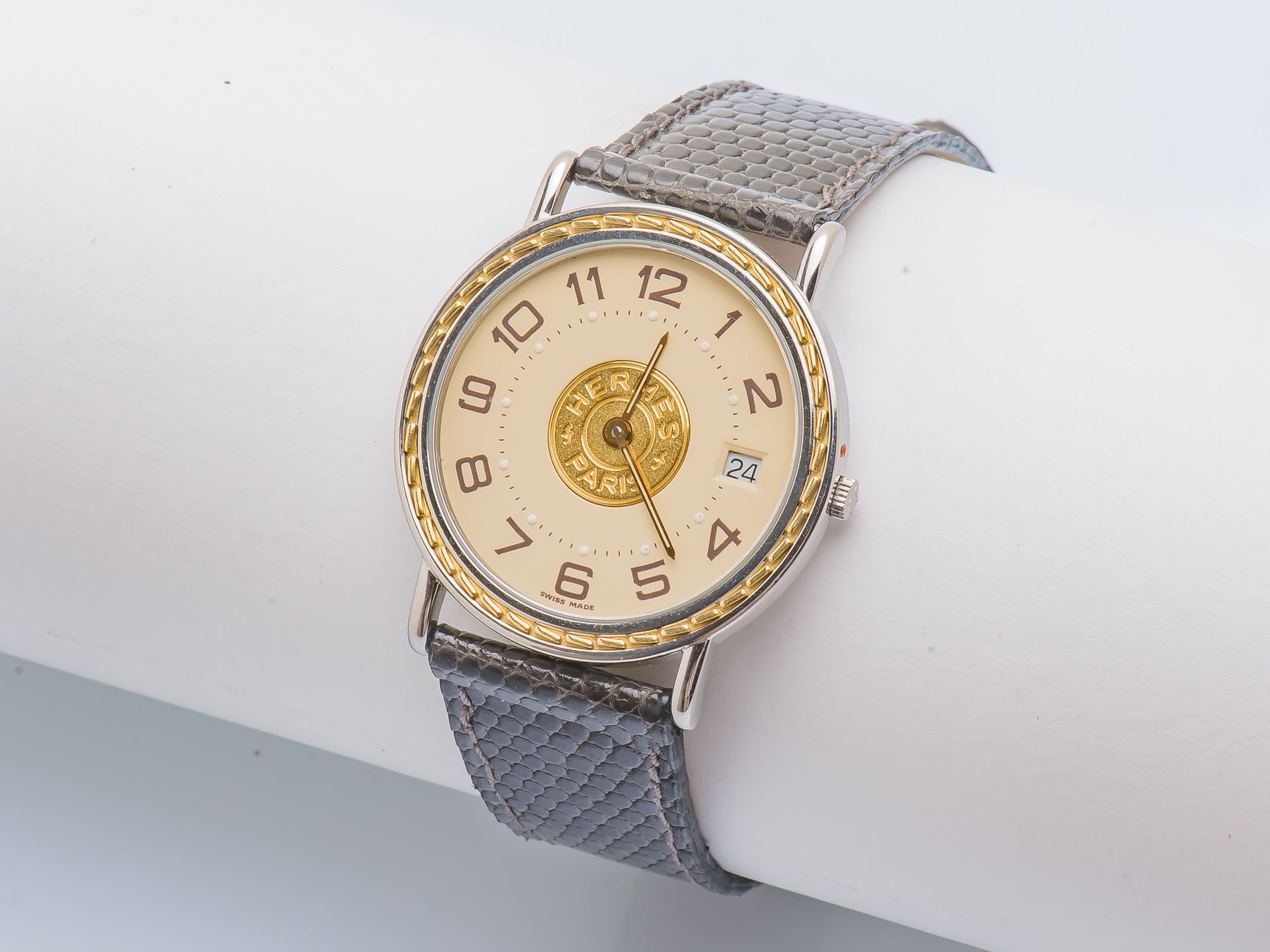HERMES 大型Sellier型号手表，圆形钢制表壳，表圈上装饰有镀金的马鞍形缝线，夹式表背（有签名和编号）。奶油色表盘上有彩绘阿拉伯数字，中间有金粉彩，日期&hellip;