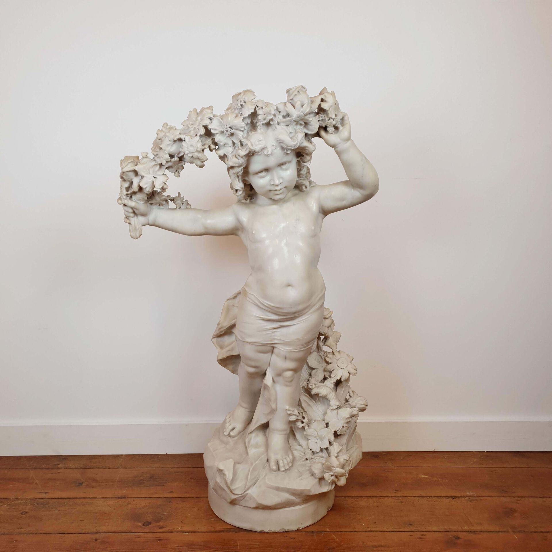 Null 
Gran escultura de mármol de un Putto que sostiene una guirnalda de flores.&hellip;