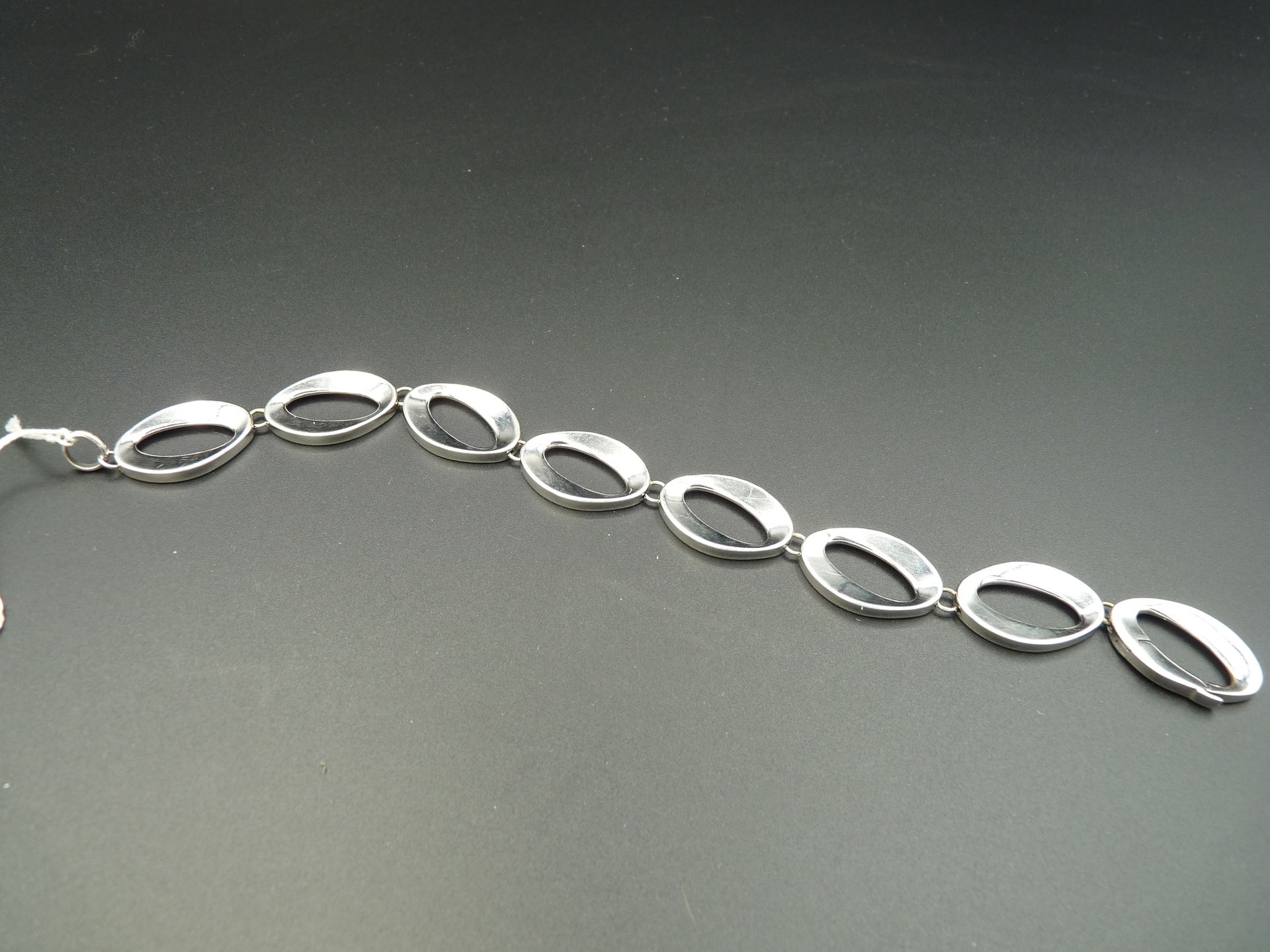 Null 光滑的18K(750/oo)白金手镯，带有椭圆形的镂空链接。长度：19厘米左右。毛重：17.6克。
