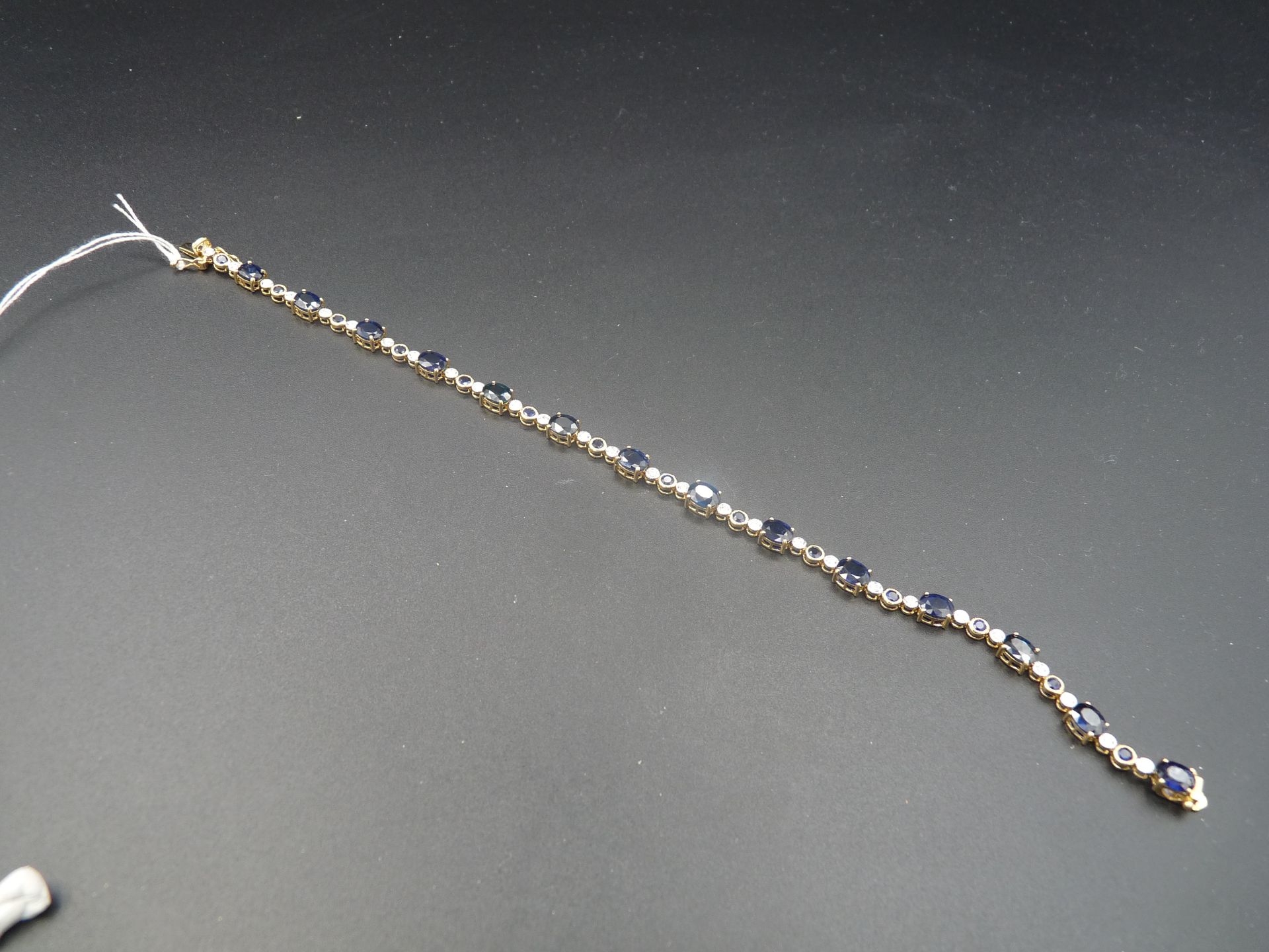 Null 双色18K（750/oo）金线手镯，由重约8克拉的椭圆形蓝宝石组成，与镶嵌有圆形蓝宝石和钻石的链节交替。长度：18厘米。毛重：7.2克。