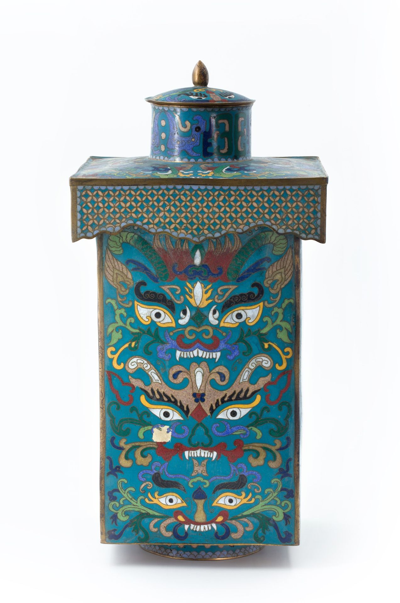 Null 正方形的CLOISONNÉ花瓶 中国，19世纪末

在绿松石地面上，它的每一面都有饕餮面具的装饰；从顶部下来的景泰蓝正面也有花瓣装饰。