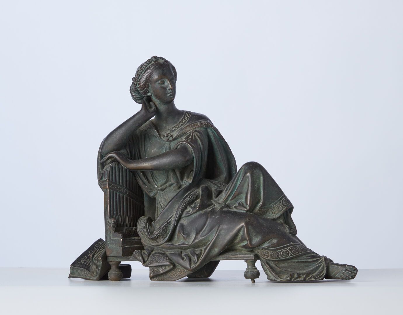 Null 音乐的寓意，代表着一个坐在乐器和乐谱前的年轻女子 
带铜锈的青铜器 
22x29厘米。