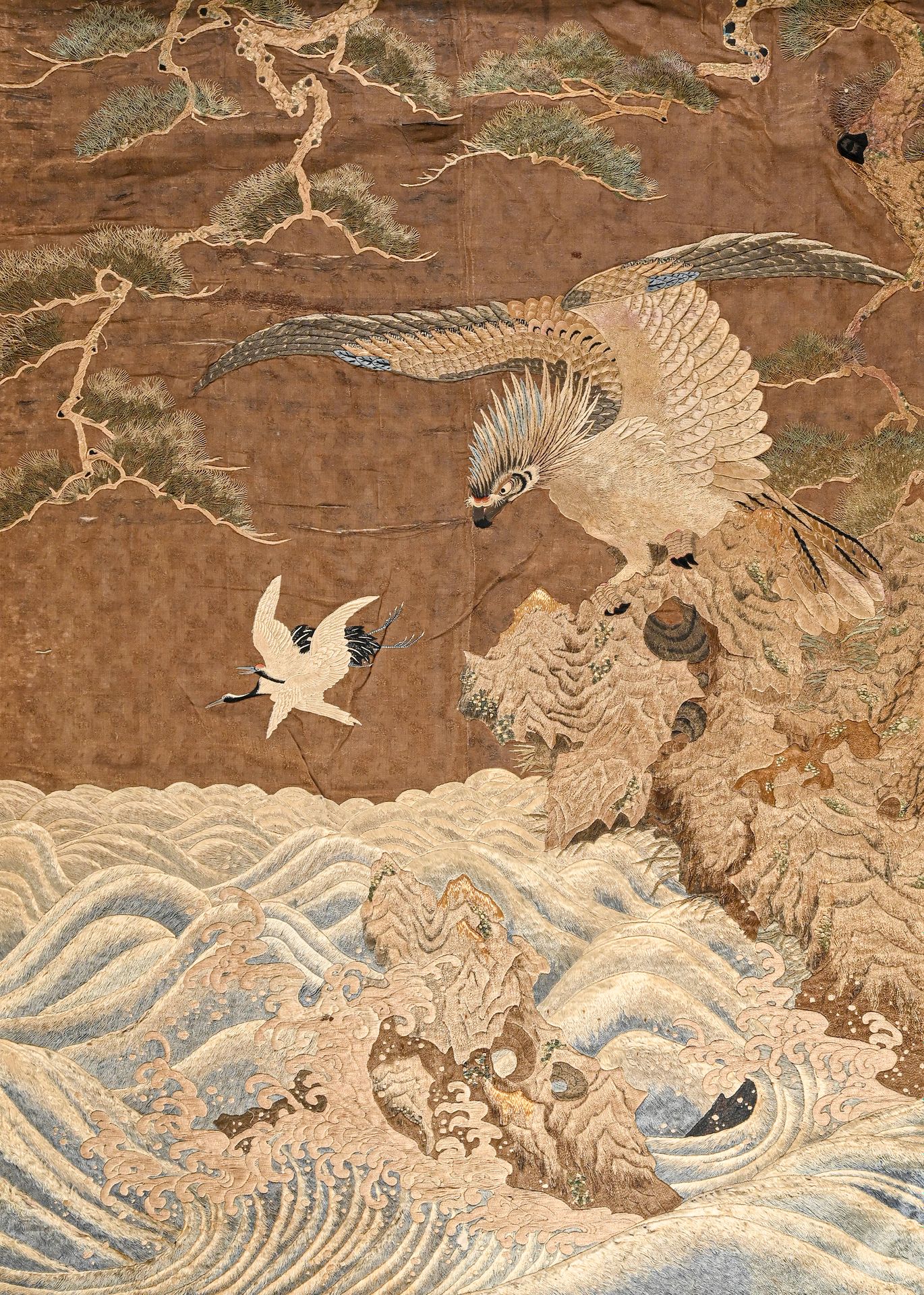 JAPON - Époque EDO (1603-1868) 用丝线和金线精细刺绣的大挂件，装饰着一只鹰栖息在惊涛骇浪中的岩石上，追逐着两只仙鹤，在棉布上装饰着&hellip;
