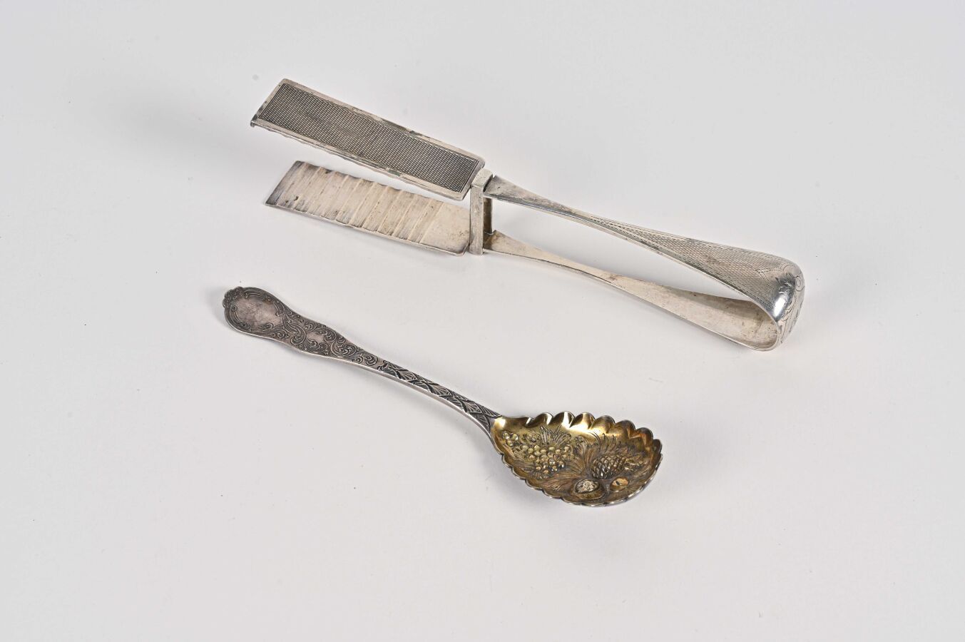 Null 套装包括一对金属G型设计的芦笋钳和一个部分镀金的水果设计的repoussé勺子BL