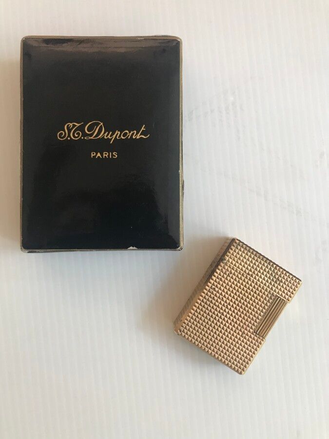 Null DUPONT 

Lighter in gold plated metal, diamond-tip decoration

In its box