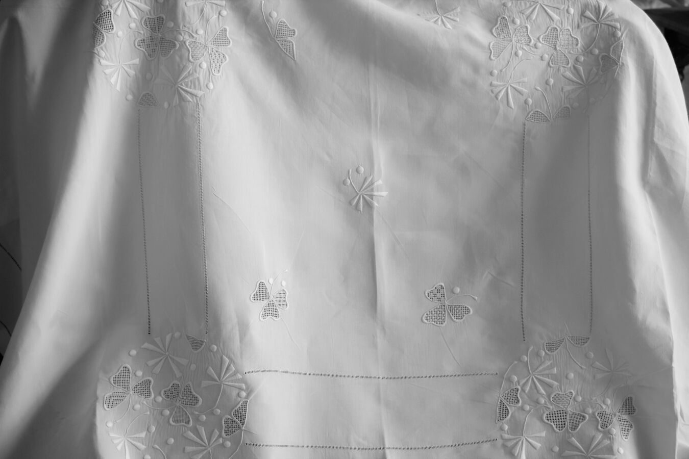 Null 桌布和12张绣花餐巾套装，20世纪上半叶。

质量上乘的亚麻布，绣有一个大的桌布，结构是由双排小天支撑着大的圆形刺绣图案，这些图案是用各种针法的散布线&hellip;