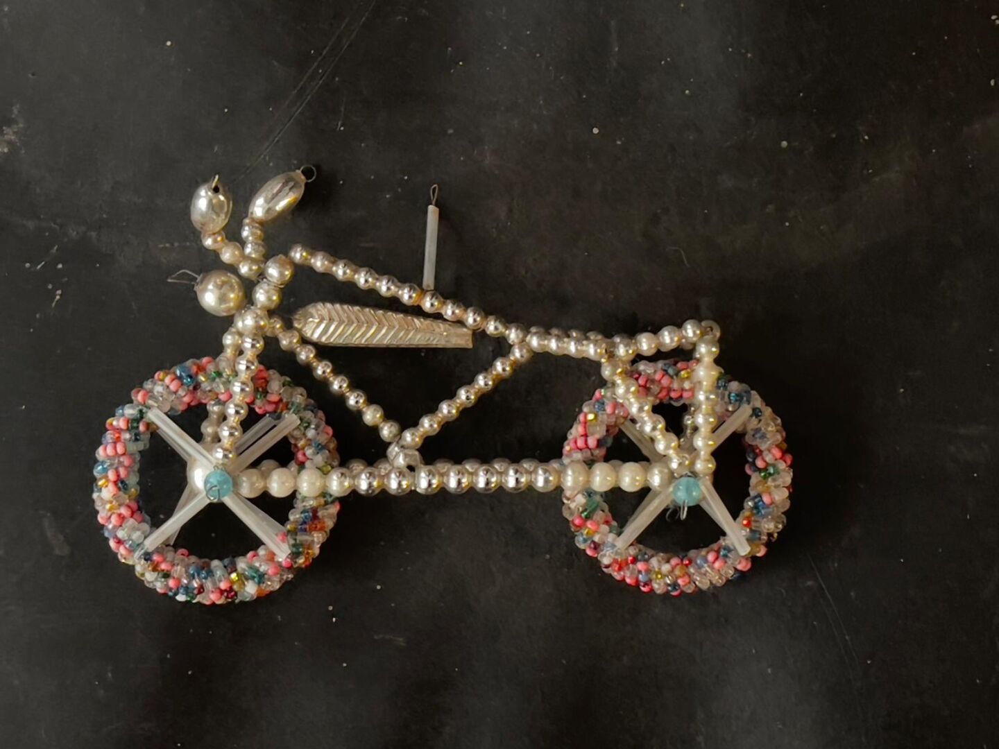 Null Ornement figurant une motocyclette aux pneus en perles de couleurs. 

Gablo&hellip;