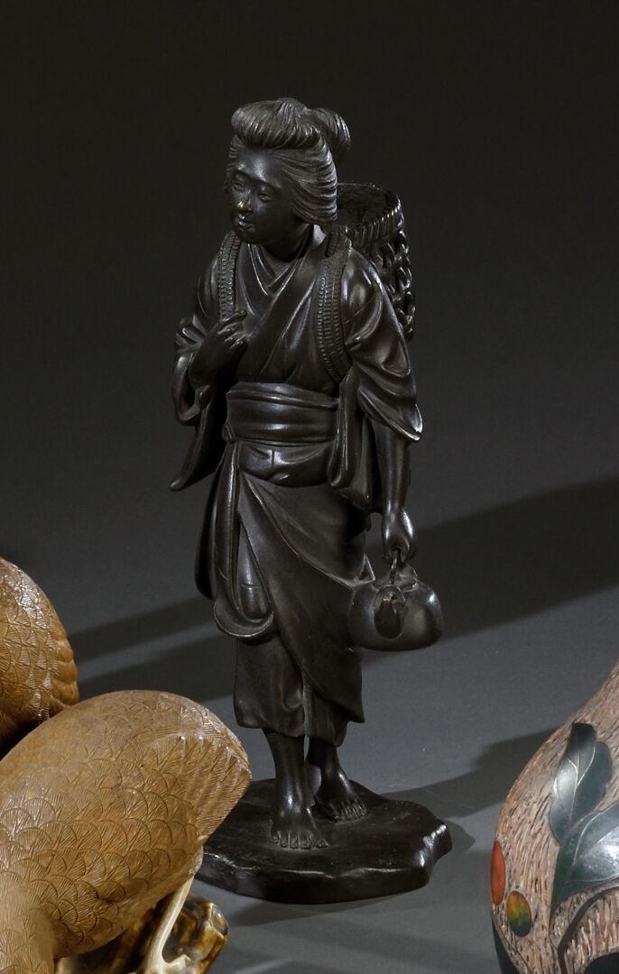 Null 日本 - 明治晚期 (1868-1912)

拿着篮子和茶壶的年轻农妇

带有棕色铜锈的青铜主题，署名为Yoshimitsu

H.25厘米