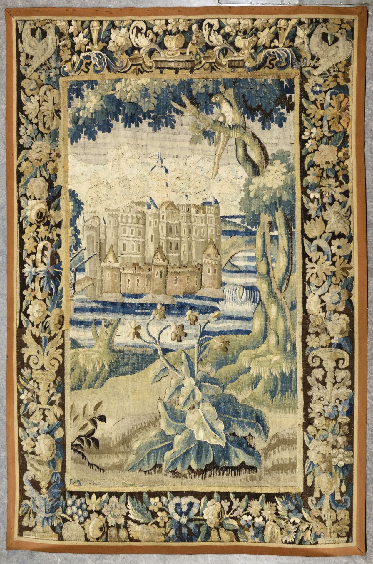 Null AUBUSSON

羊毛和丝绸挂毯面板表现了一个被水包围的城堡。美丽而宽大的边框，有叶子和水果装饰

17世纪末和18世纪初

H.207 cm - &hellip;