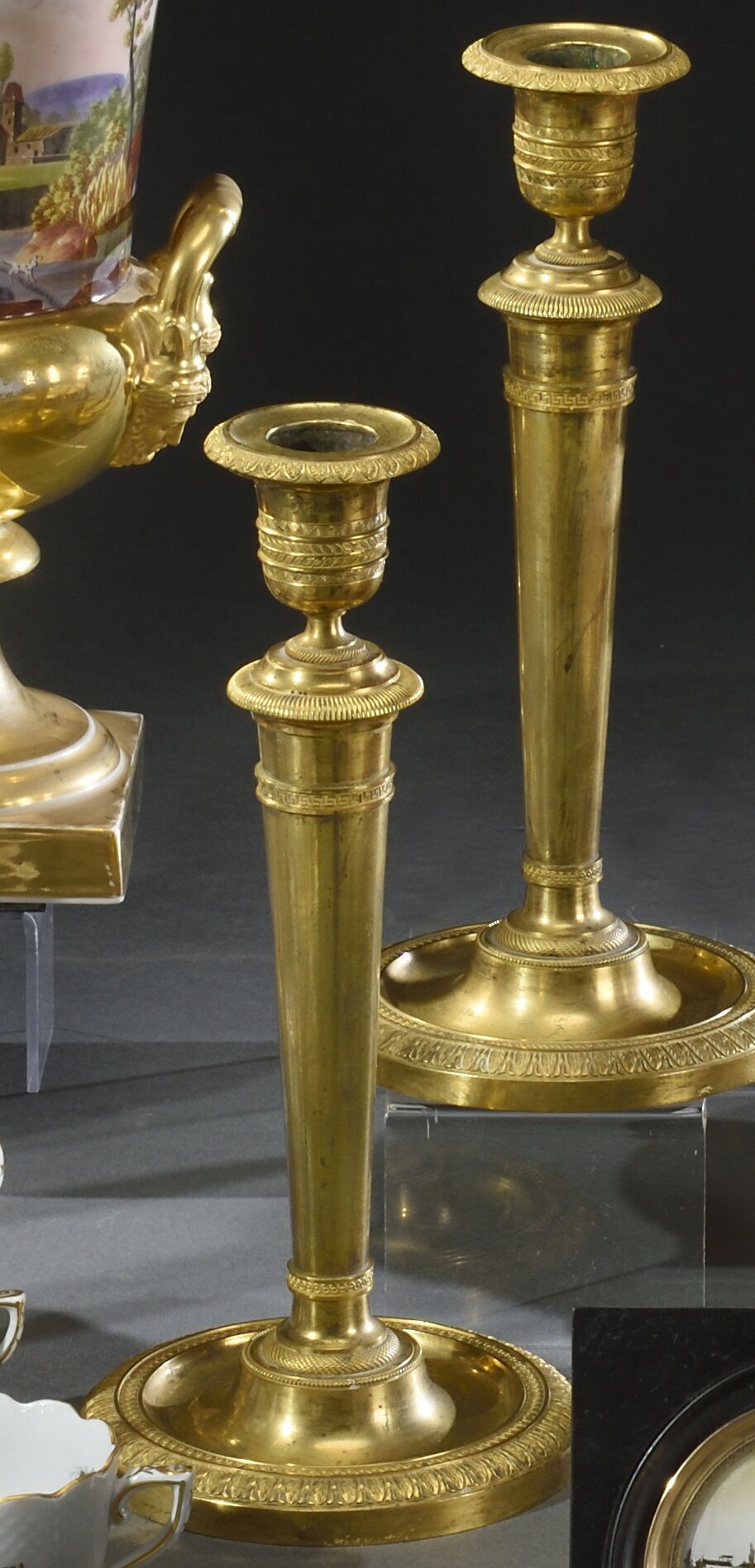 Null Pair of gilt bronze candlesticks, the base with hollow stave bordered by a &hellip;