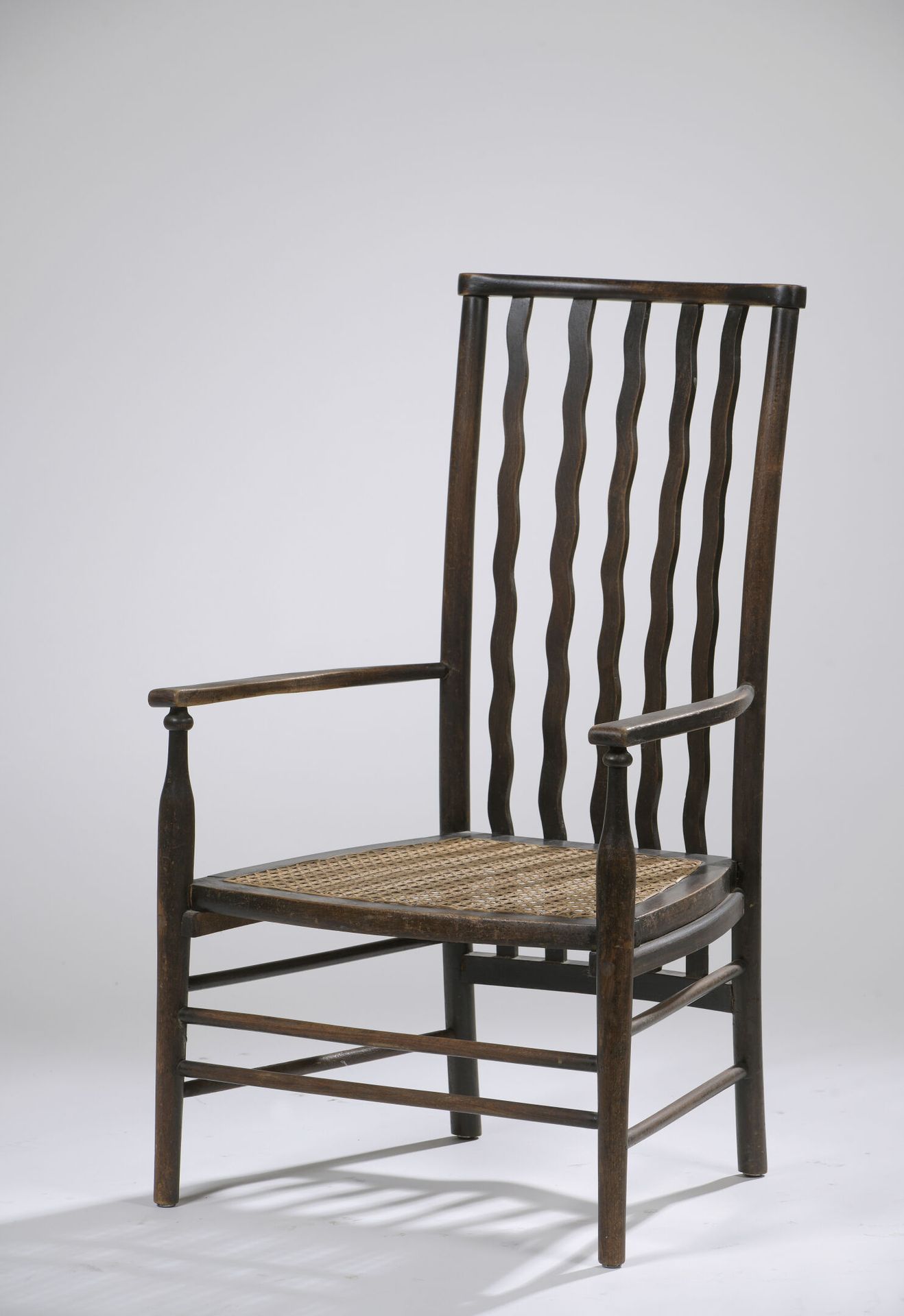 Null 20世纪初的艺术和工艺作品。

可能是自由版。

优雅的低矮扶手椅。靠背由移动形式的板条分割，座位是藤条。着色的黑色山毛榉。

H.85 cm - W&hellip;