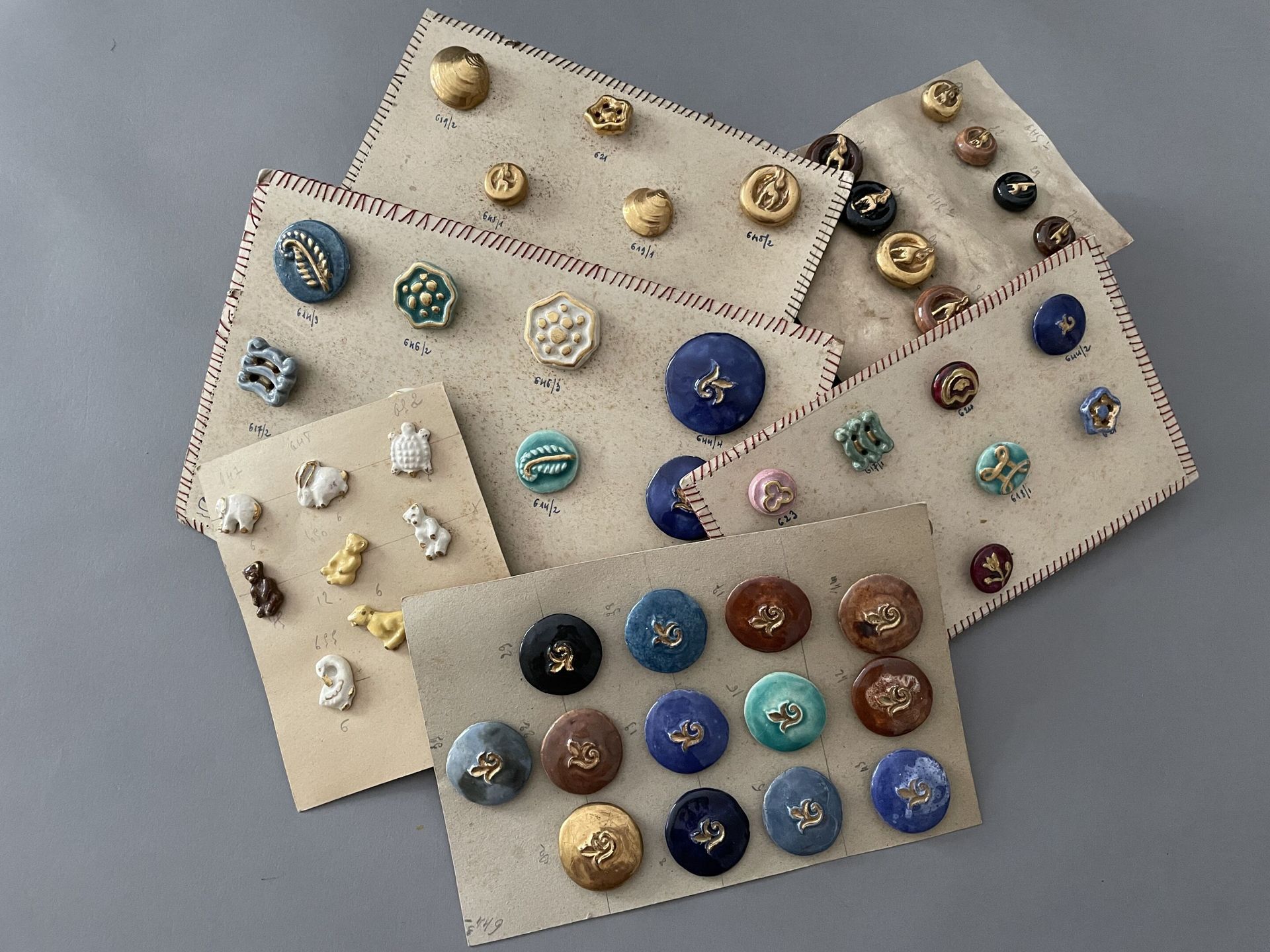 Null 一套大约二十五个花式和高级时尚的纽扣设计，大约在1940年，各种尺寸的纽扣都是用上釉和镀金的陶瓷制成的，主要的设计是上面和下面描述的模型，包括花朵、甲&hellip;