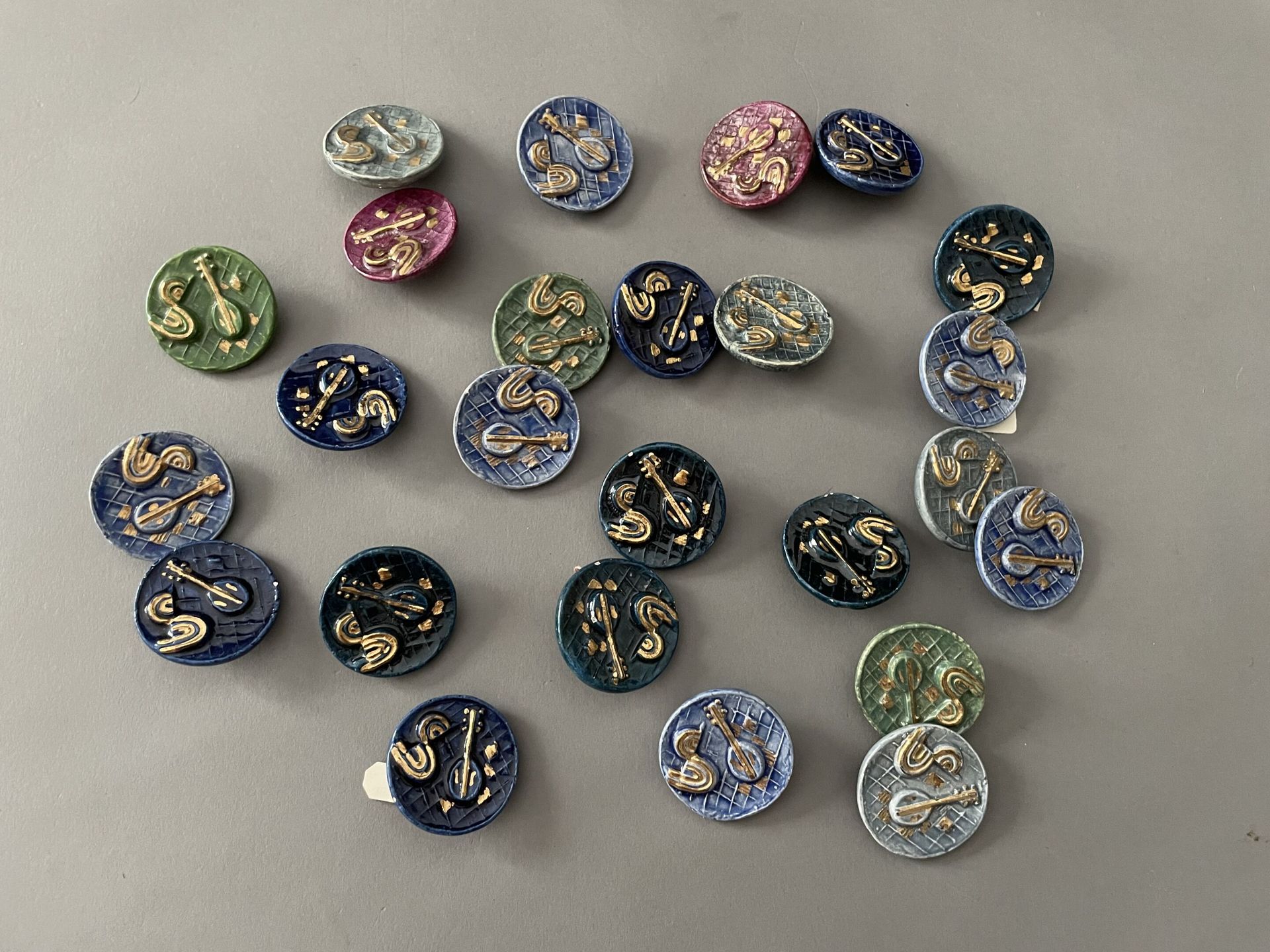 Null 一套24颗以音乐为主题的高级时装大陶瓷纽扣，约1940年，圆形珐琅和镀金陶瓷纽扣，金属和模制紧固件，装饰有5种颜色的乐器，（其中两颗有小事故）。 

&hellip;