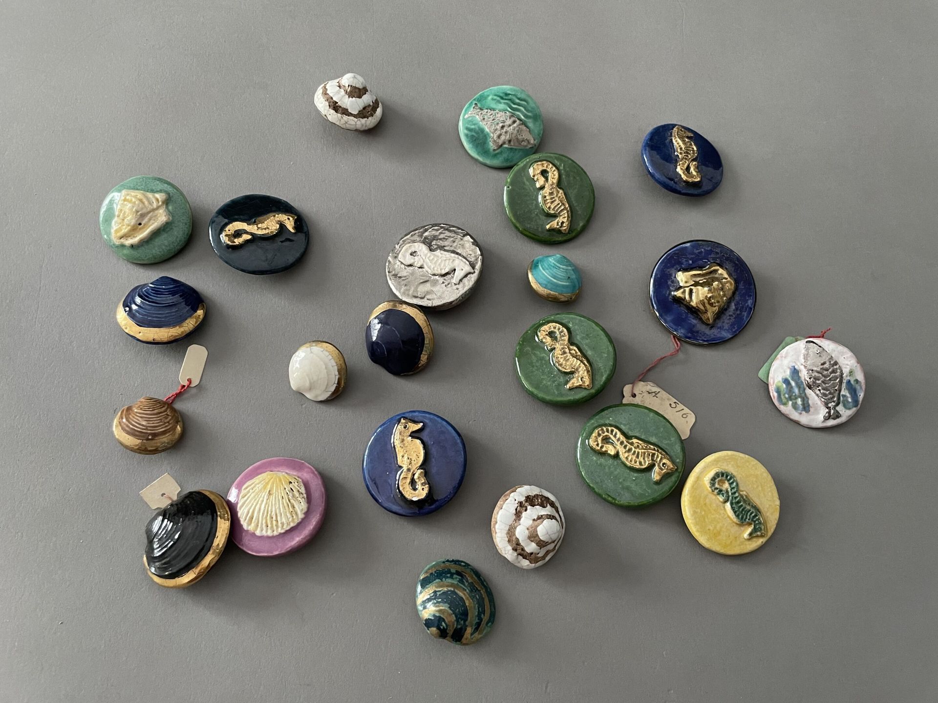 Null 大约在1940年，为高级时装设计的二十二个陶瓷纽扣的重聚，五种型号的上釉、镀金和银色的陶瓷纽扣，带有金属和模具的附件。八个大的圆形纽扣和八个以贝壳为特&hellip;