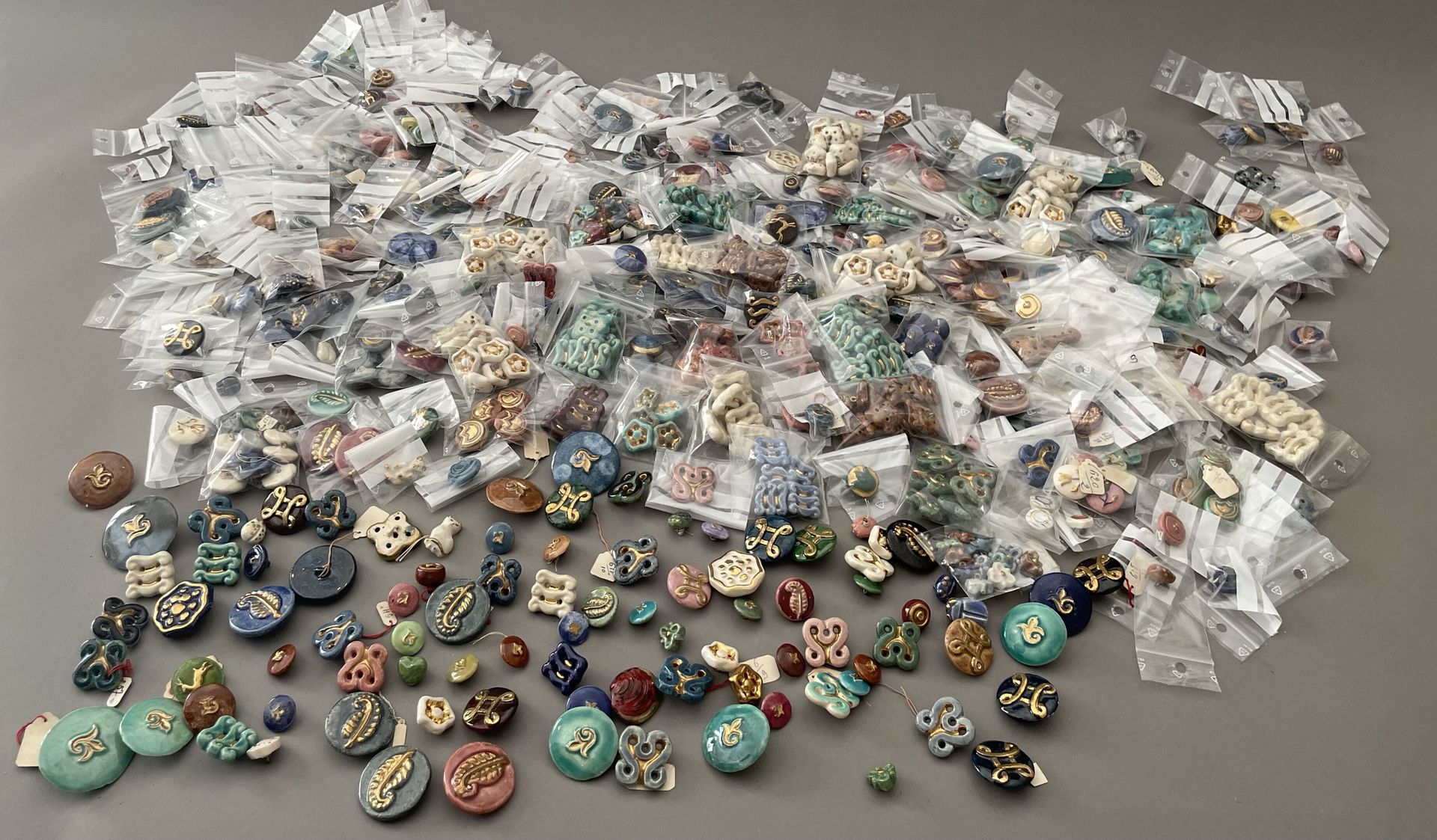 Null 约1940年的花式和高级时装纽扣的重聚，大约有450个带金属或穿孔附件的珐琅和镀金陶瓷纽扣从原来的盘子上脱落。 两套共约108件，有花纹装饰，152件&hellip;