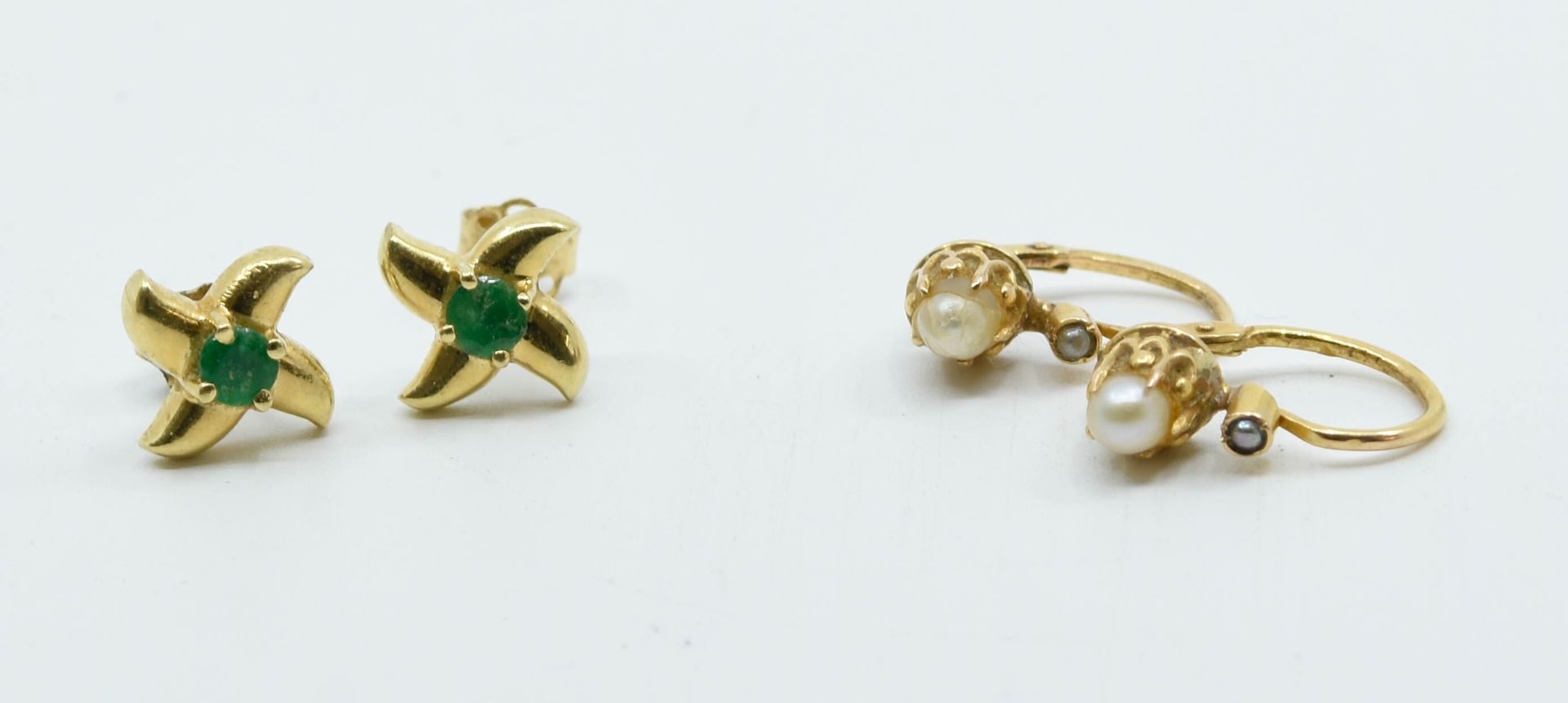 Null 拍品包括两对18K(750°/°)黄金耳环：一对Dormeuses，各镶嵌一颗珍珠；一对耳片，形成一朵花，中间镶嵌一颗小绿宝石。 
总毛重：3克