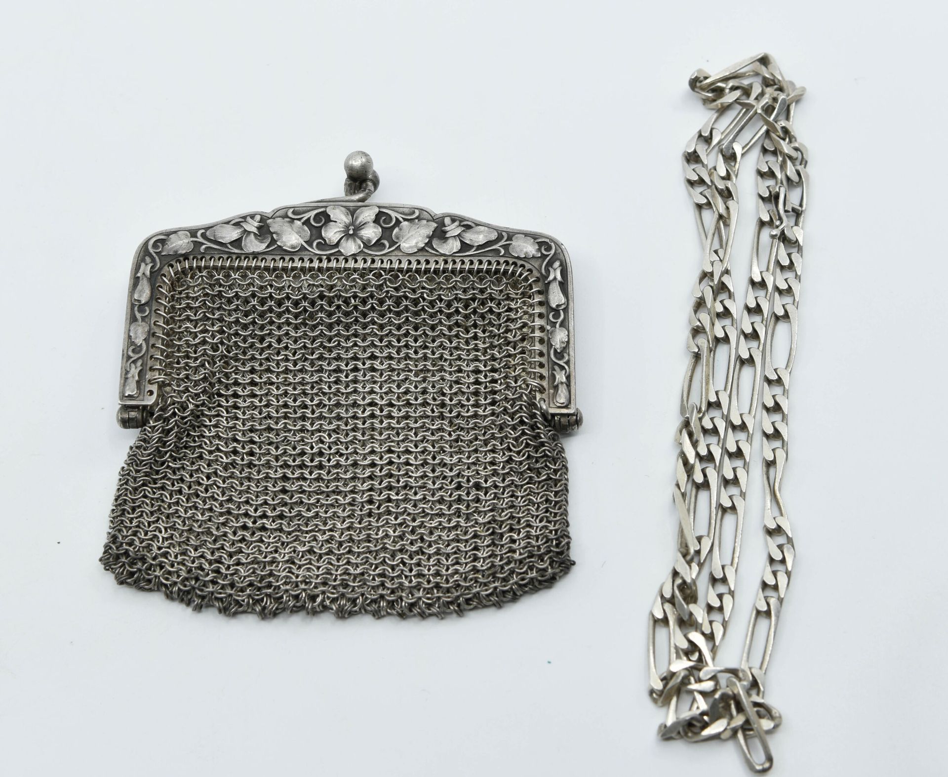 Null 银色和银色网状硬币钱包（800°/°），饰有叶子图案
约1900年
重量：61.5克
小事故

一条银质费加罗链，重量：19克