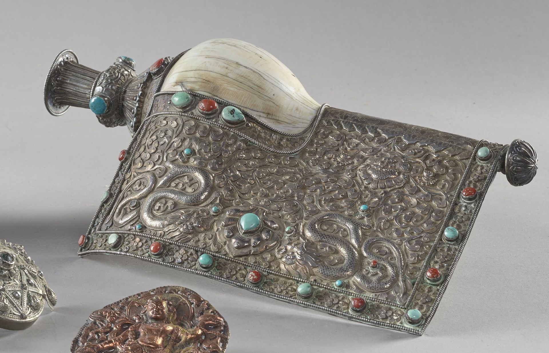 Null 西藏，19世纪末/20世纪初
祭祀用的喇叭(sankha)由海螺和它的银质支架(800‰)组成，有双龙围绕着树叶中的愿望珠宝的重塑装饰，镶嵌着绿松石和&hellip;