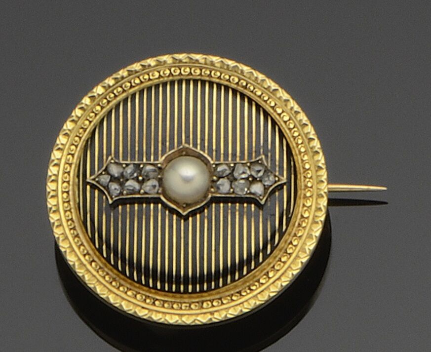 Null Broche ronde en or jaune 18K (750°/°°) à décor ciselé agrémenté d'émail noi&hellip;