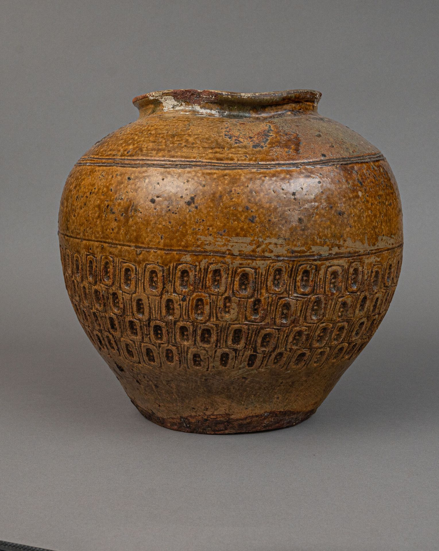 Null 琥珀棕色釉陶罐，可能产于越南，18 世纪
罐身底部有浮雕装饰，椭圆形图案中重复出现三个圆点。颈部有缺口，已修复，釉面缺失。
H.高 31 厘米 - 宽&hellip;
