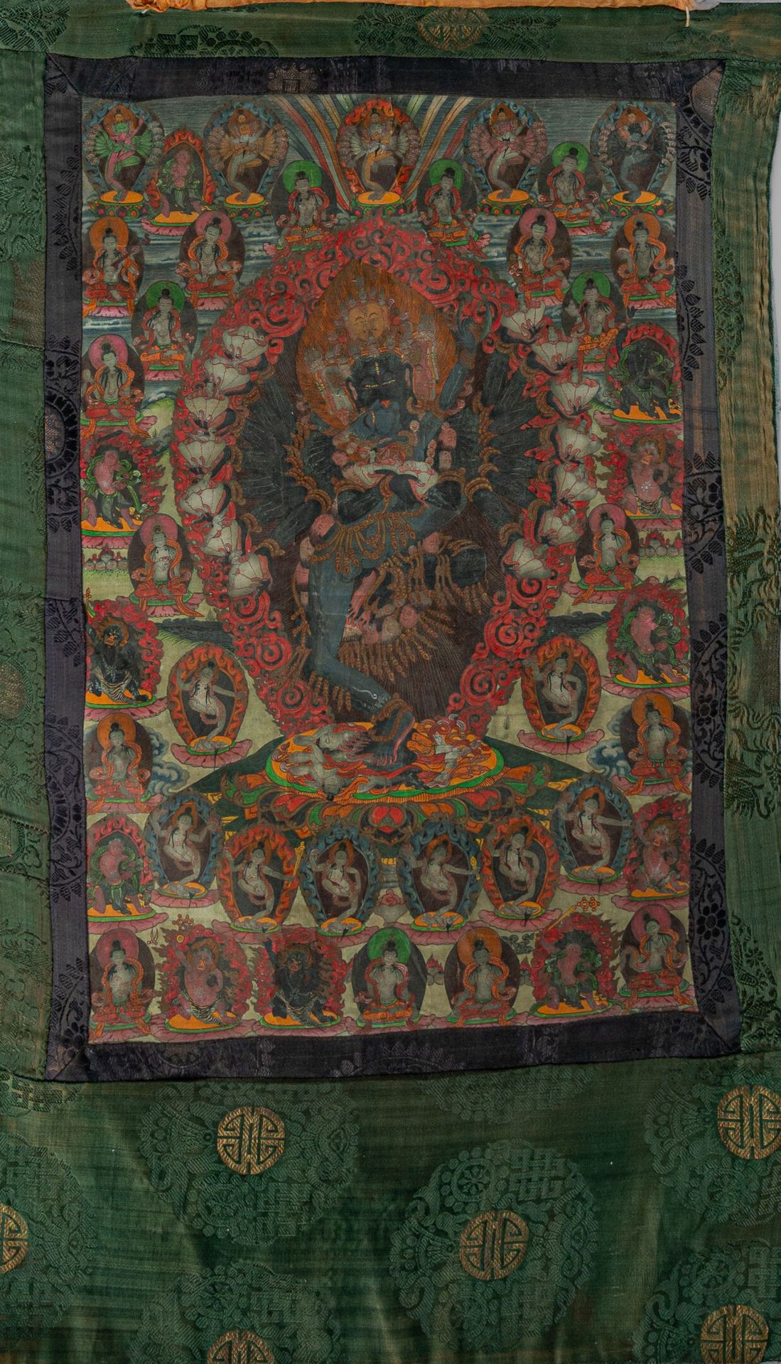 Null 唐卡，西藏，19 世纪 
画布上的色粉，描绘的是一尊八头十六臂的午夜蓝色神像（手持卡帕拉），她拥抱着中央的女神，周围环绕着达基尼和其他神像，装裱在丝绸&hellip;
