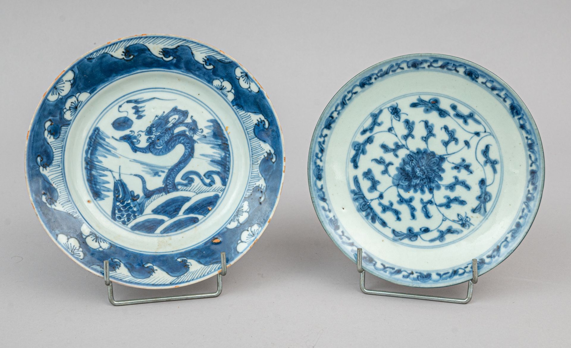 Null 两件青花瓷盘，中国出口（东南亚），19 世纪
一个背面饰荷花卷轴、花枝和款识，另一个中央饰波浪中的龙和鲤鱼、波浪和翼上的梅花，背面饰四个吉祥物和风格化&hellip;