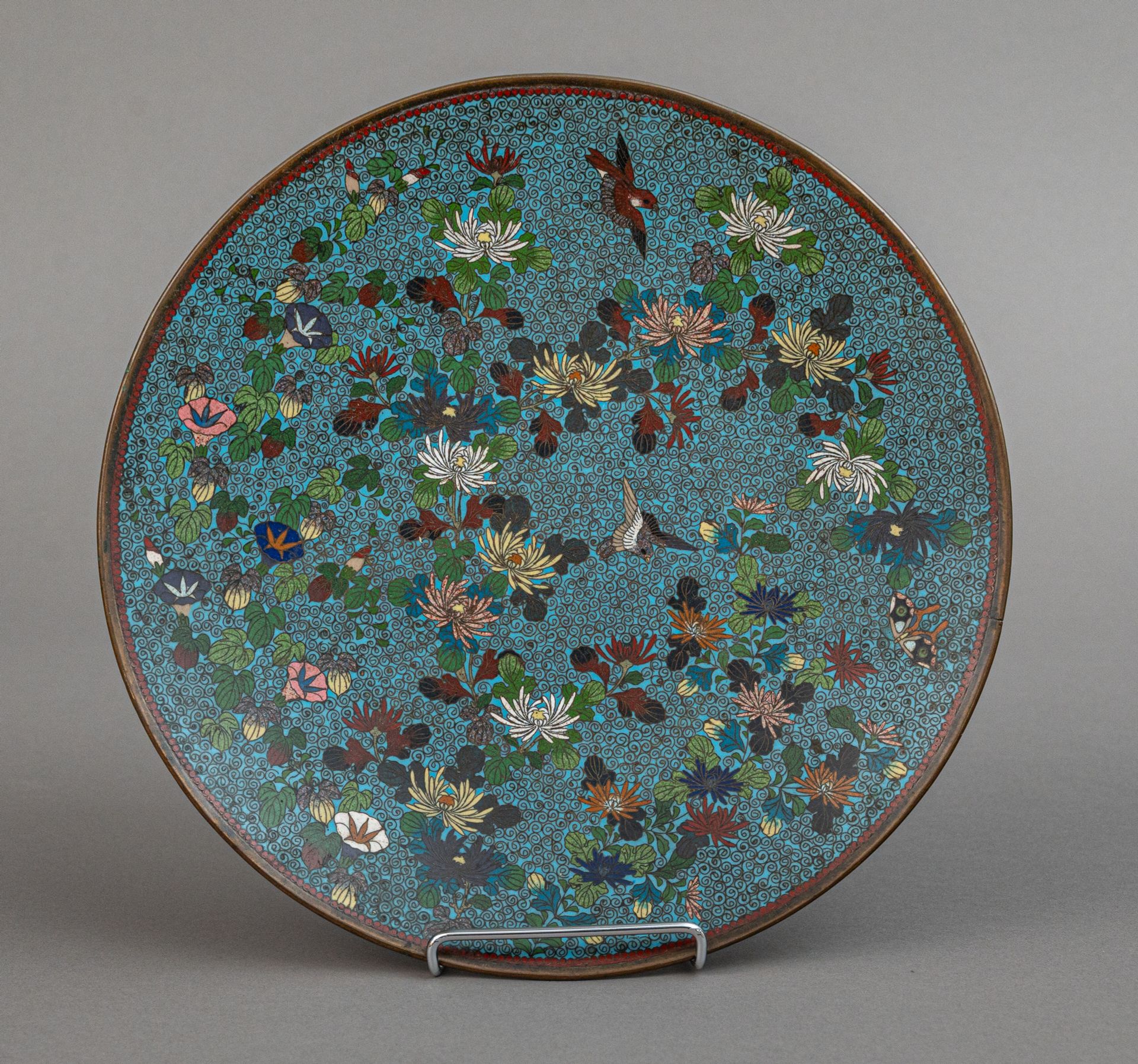 Null 铜盘上的掐丝珐琅，日本，明治时期（1868-1912 年）
以螺旋纹和天蓝色珐琅为背景，装饰菊花和蓼属植物的花枝以及几只飞翔的鸟，背景在背面重复，底座&hellip;