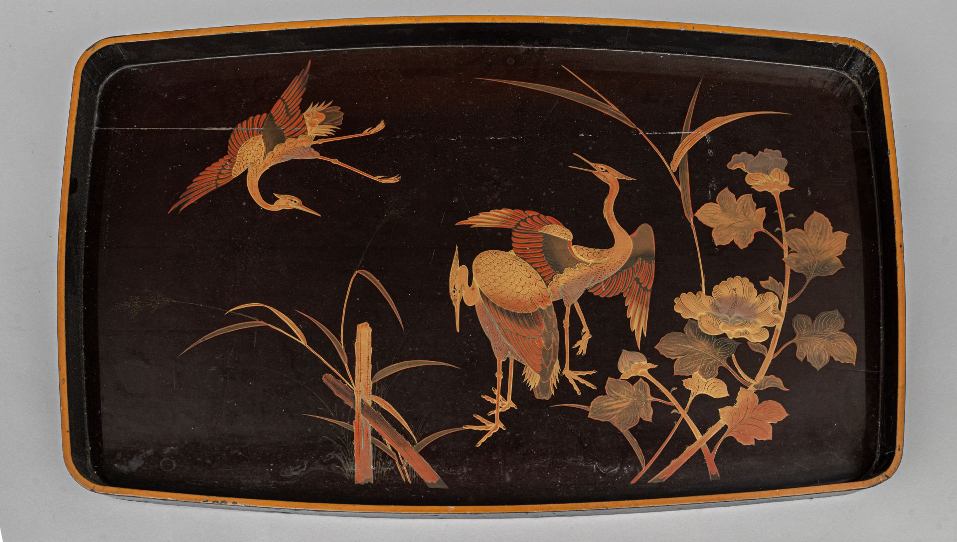 Null 莳绘漆盘，日本，20 世纪早期
黑底上用金、银和红漆装饰三只仙鹤，一只在飞翔，两只站在一些花草旁，边缘镀金。有裂缝和缺口。
H.高 47.6 厘米 -&hellip;