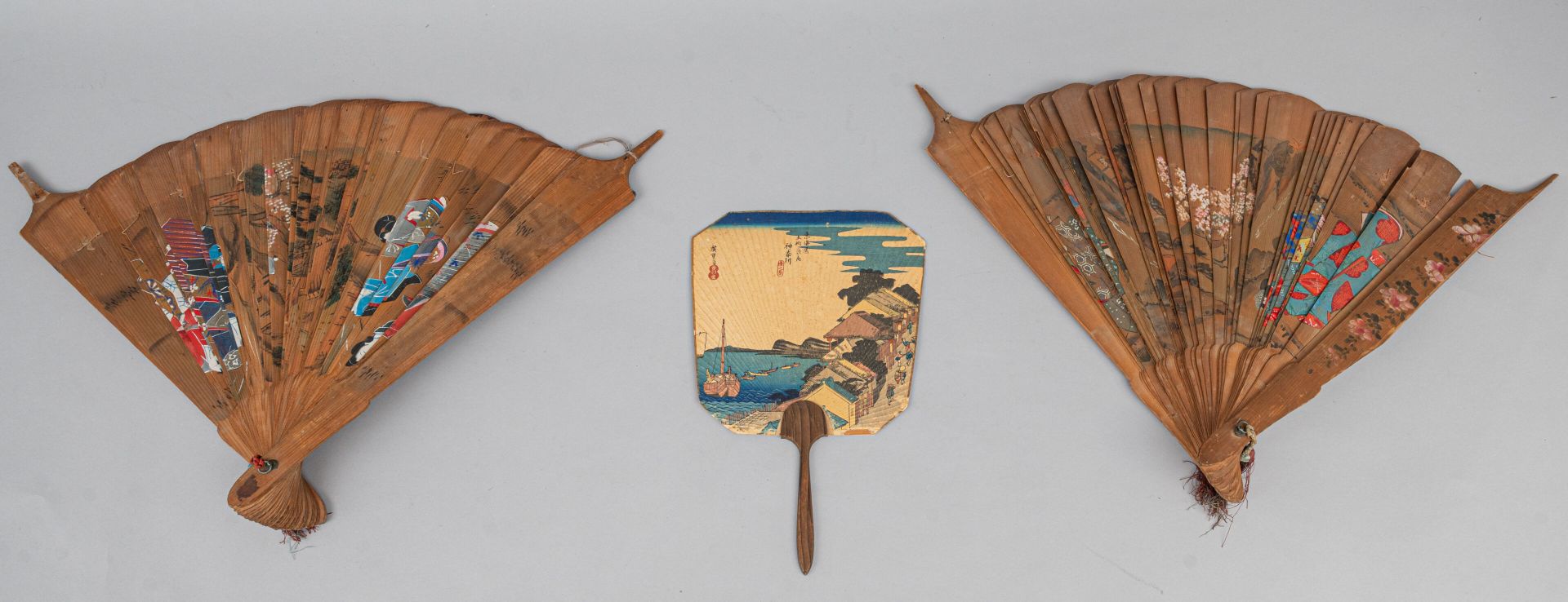 Null 三把扇子，日本，19 世纪 
一把硬质梯形手扇，一面饰有宇多川广重的版画，该版画出自神奈川的 "五十三回 "系列（小污点，底部有磨损和撕裂）；还有一对&hellip;