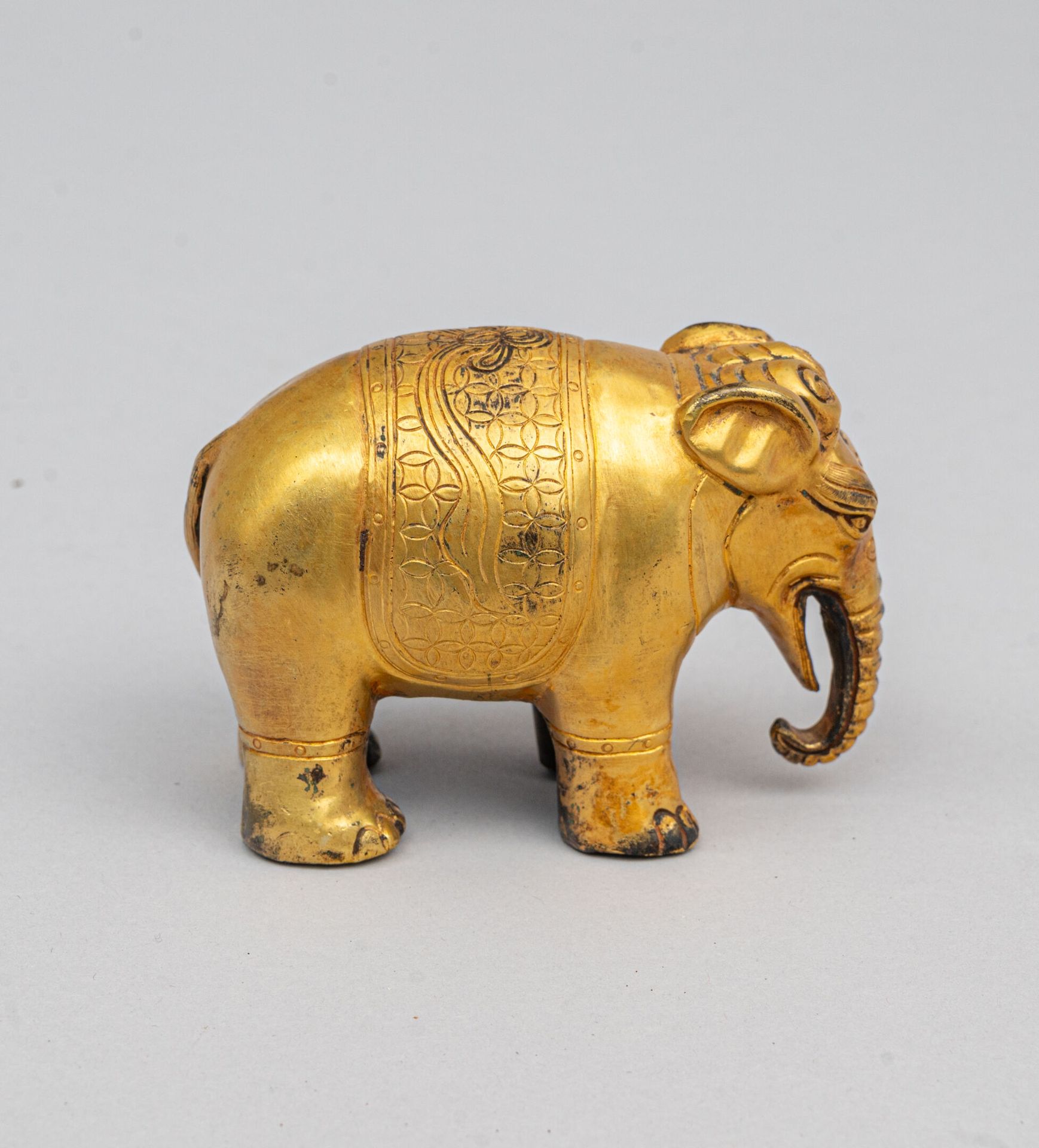 Null 金漆铜象，泰国，19 世纪末/20 世纪初
站立，背上披着几何图案的毯子，中空（腿和腹部敞开）。漆面有磨损。
H.7 厘米；长 10 厘米