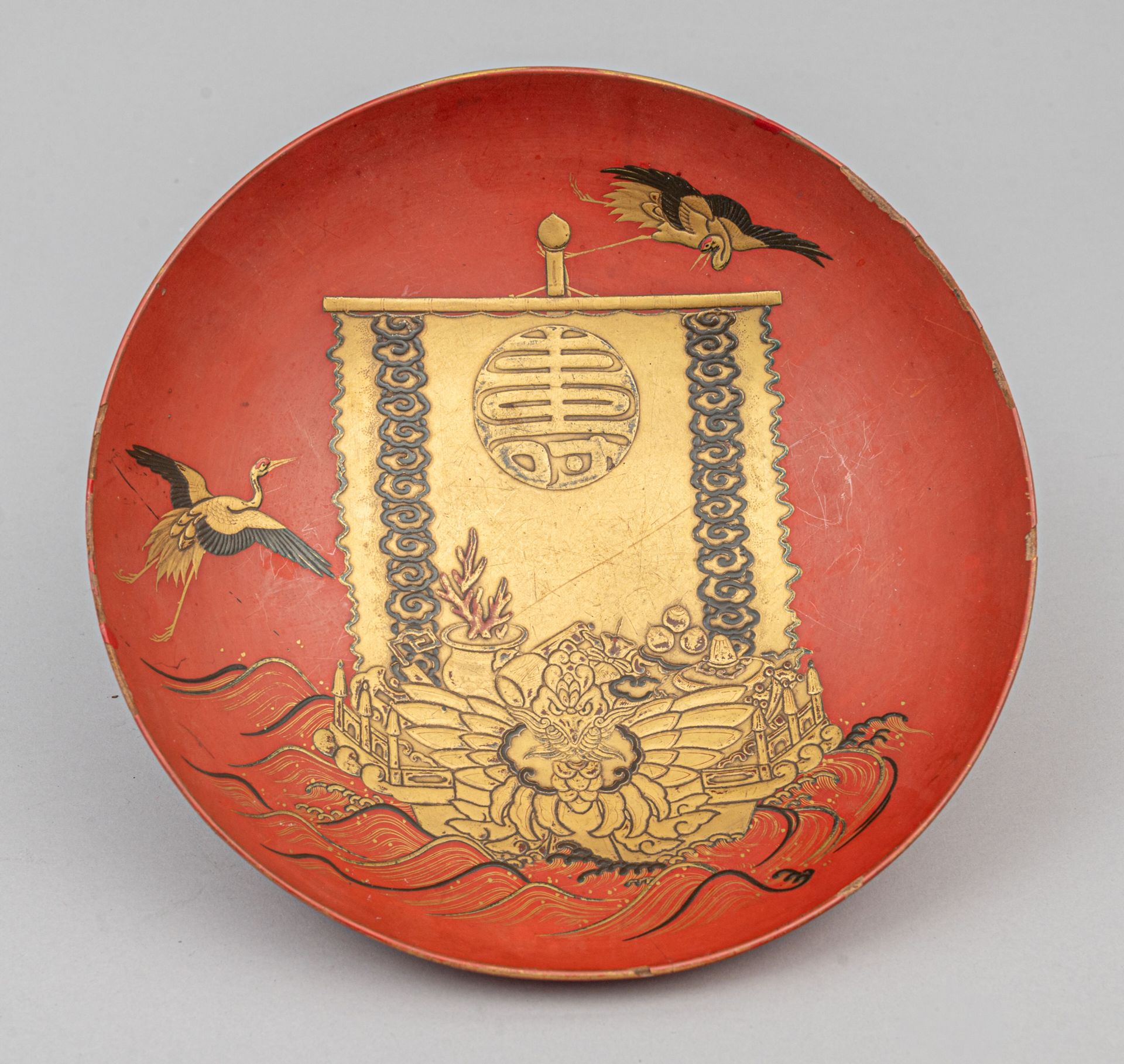 Null 莳绘漆碗，日本，明治时期（1868-1912 年）
红底黑色和金色装饰，背景描绘了装满七福神各自属性的高原船，船帆上有一个巨大的 "寿 "字，在波浪中&hellip;