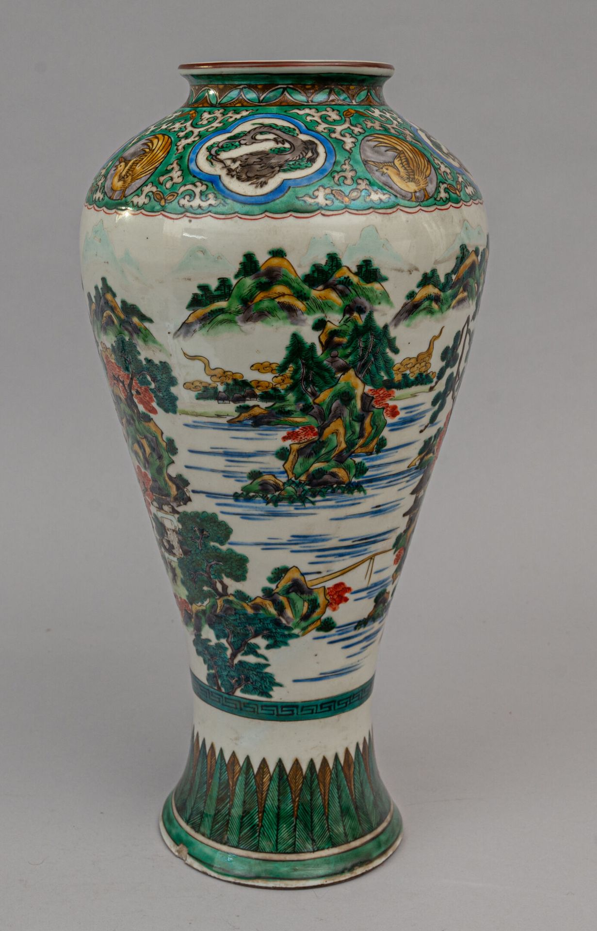 Null 绿色古谷瓷瓶，日本，19 世纪 
花瓶呈秃顶状，瓶身饰有大型湖光山色，肩部饰有绿底龙鸟图案，底有造型叶片。底有穿孔（带标记），底有缺口。 
H.40.&hellip;