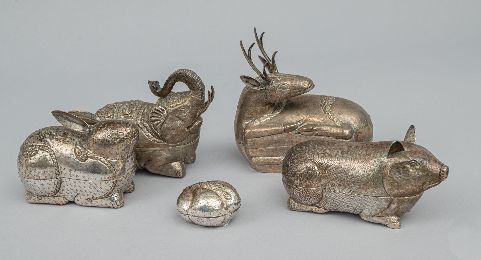 Null 五个变形银质和镀银槟榔盒，东南亚，20 世纪早期
表现的是兔子、猪、鹿、大象和青蛙，金属表面压印并刻有装饰图案，其中两个上有印记。
高 4 至 15 &hellip;