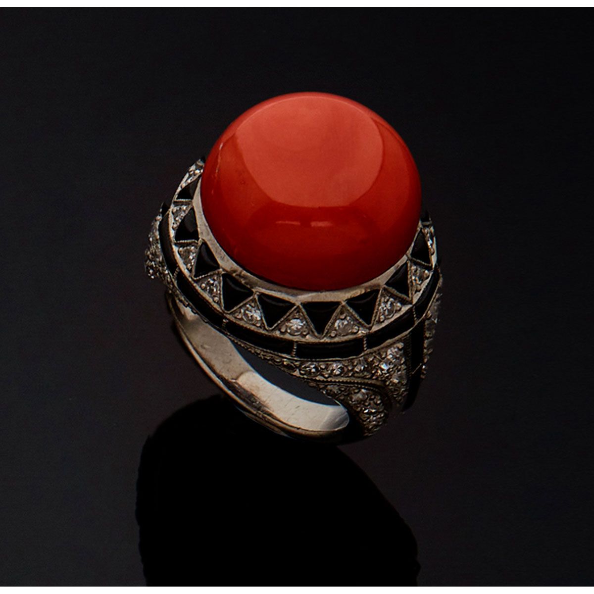 Null 800毫米的铂金戒指，有一个大的凸圆形珊瑚，主体是由校准的黑玛瑙、半切和八切钻石组成的几何装饰。法国的工作。

B.P. 20,8g。- TDD 53