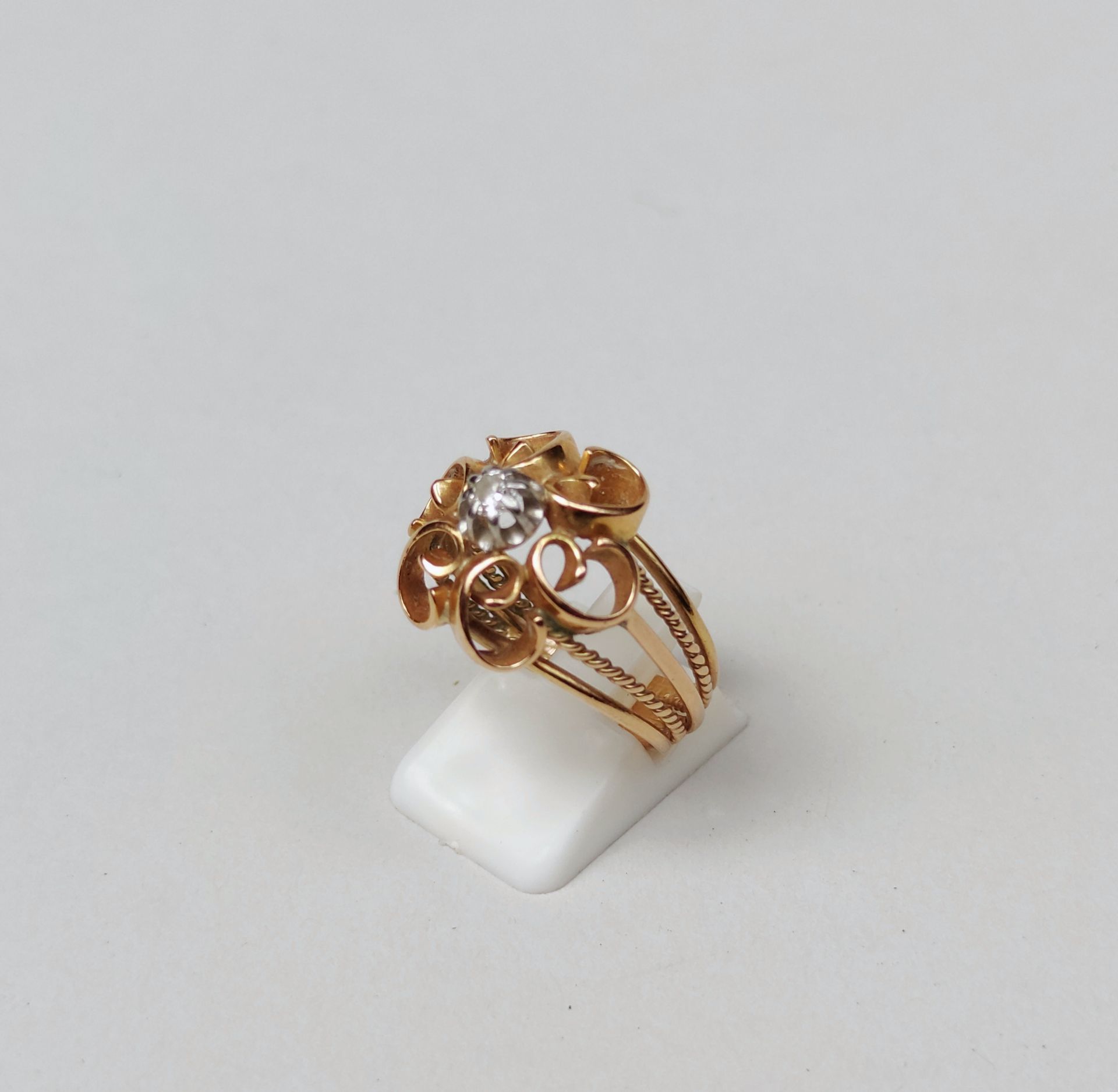 Null 
镂空黄金戒指，以小切工钻石为中心的涡纹图案 毛重：7.7克