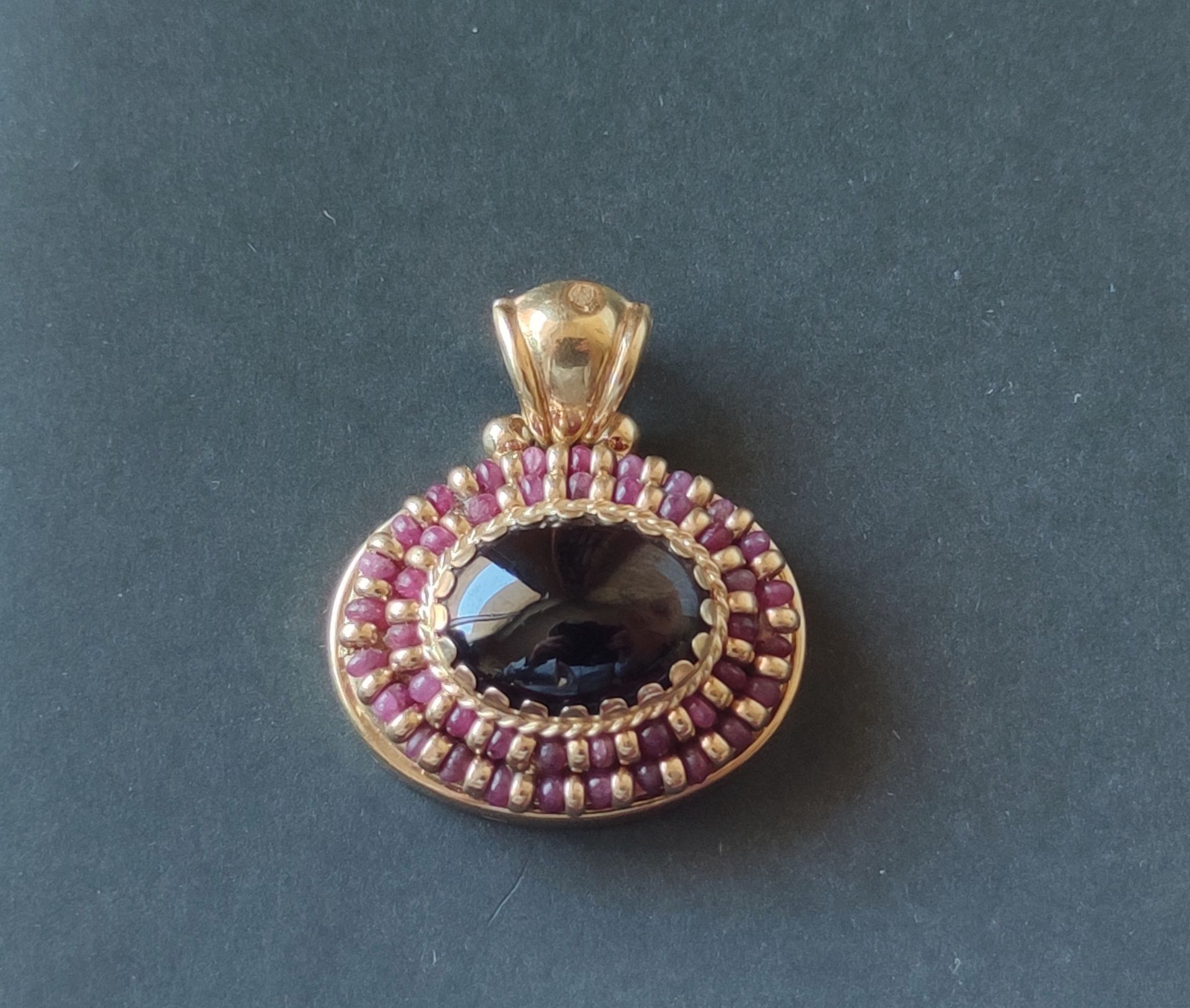 Null Yellow gold pendant 750°/°°, oval shape, decorated with a garnet cabochon i&hellip;