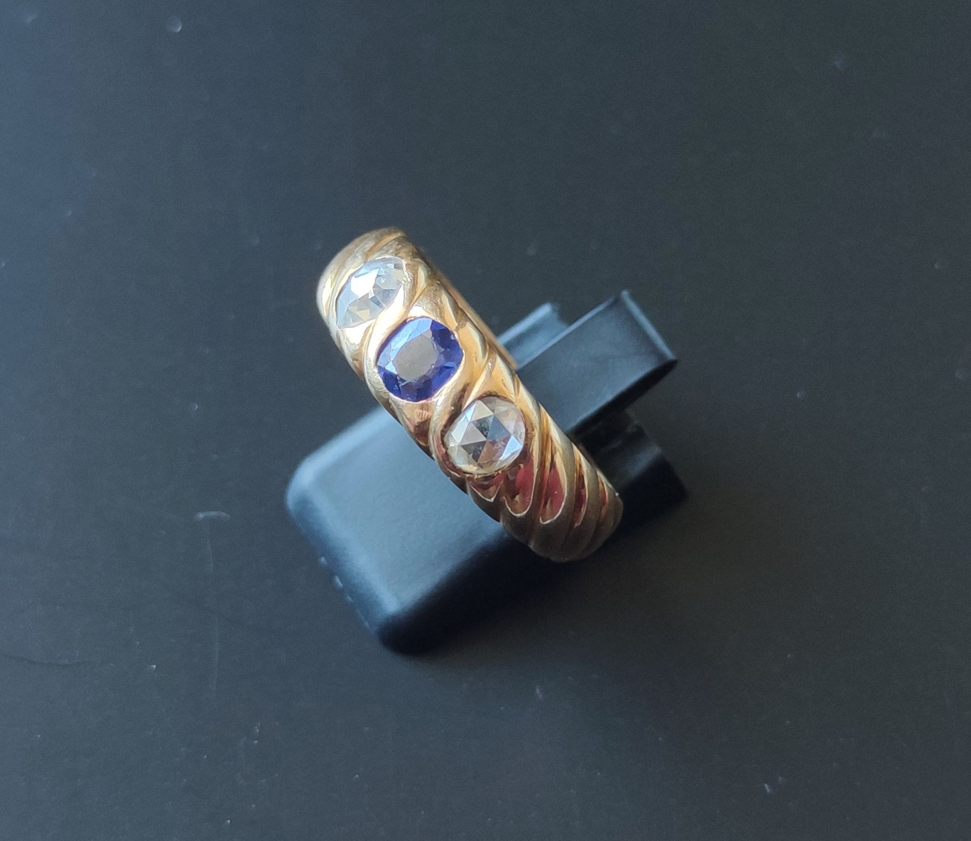 Null 
750°/°的黄金戒指，有格子图案，镶嵌着一颗蓝色的石头（严重磨损）和两颗切割钻石。 重量：9.3克。 手指大小：64。