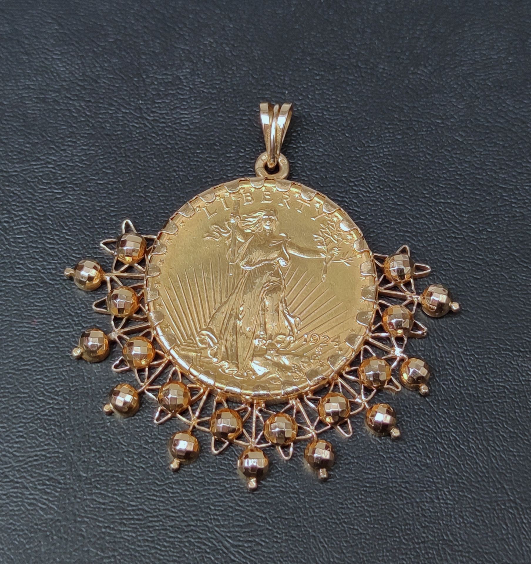 Null 
750°/00黄金吊坠，饰有一枚圣戈登1924年的20美元金币，在半圆的叶子上装饰有球。 重量：45.3克