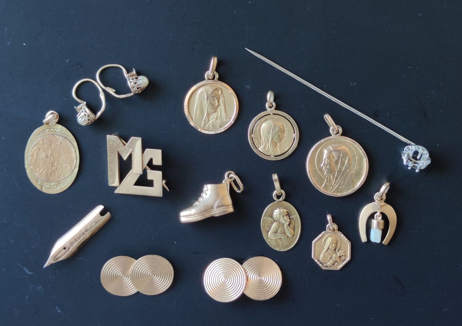 Null 750°/00的黄金和白金拍品包括：六枚奖牌，其中一枚带有珍珠母，一枚胸针，一对袖扣，一支笔尖，两个吊坠，一对耳环，一个针座 总重量：24.1克
