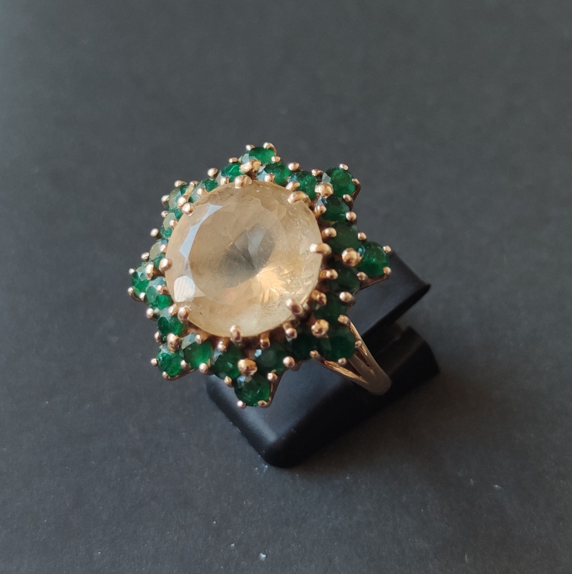 Null 
戒指，750°/°的黄金，在一圈小切口祖母绿中镶嵌一颗黄水晶，经测试总重17.3克，缩水后手指尺寸：57