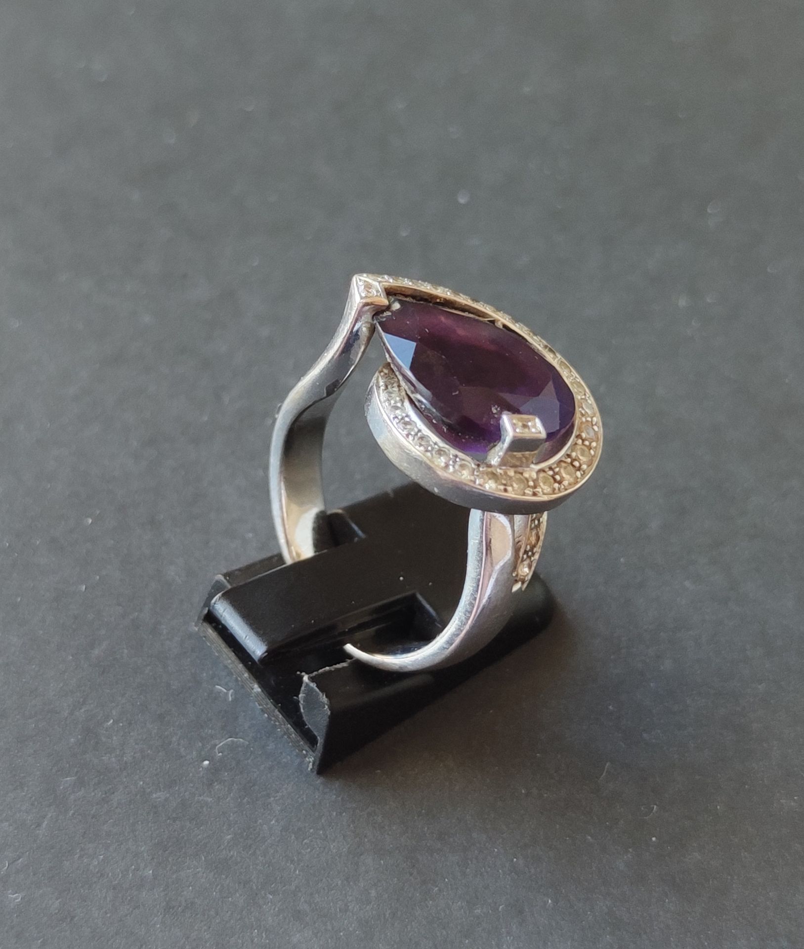 Null 
戒指，750°/°白金镶嵌，在一圈小钻石中镶嵌一颗切割紫水晶，经测试总重11.8克，手指尺寸：56 1/2
