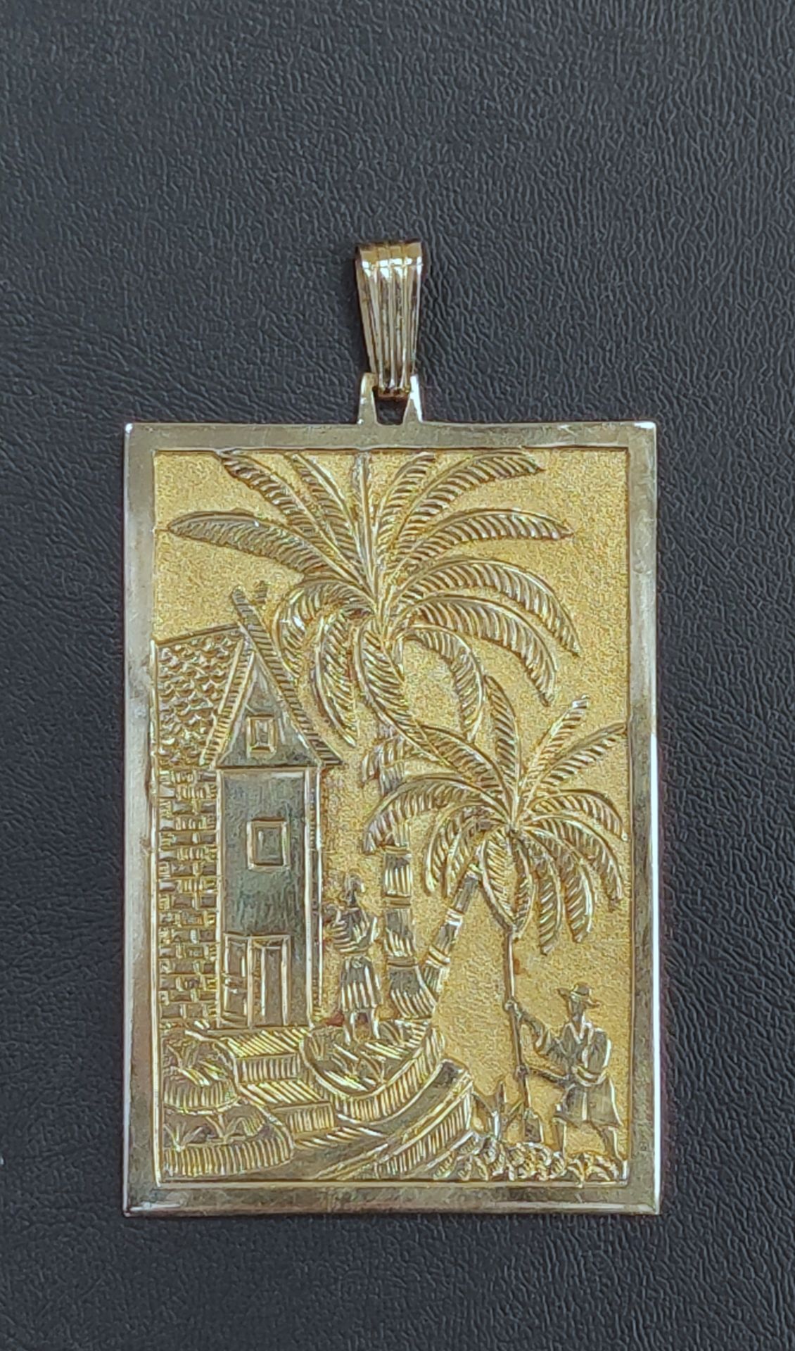 Null 
Piatto pendente in oro giallo 750°/00 con personaggi, casa e palme Peso: 6&hellip;