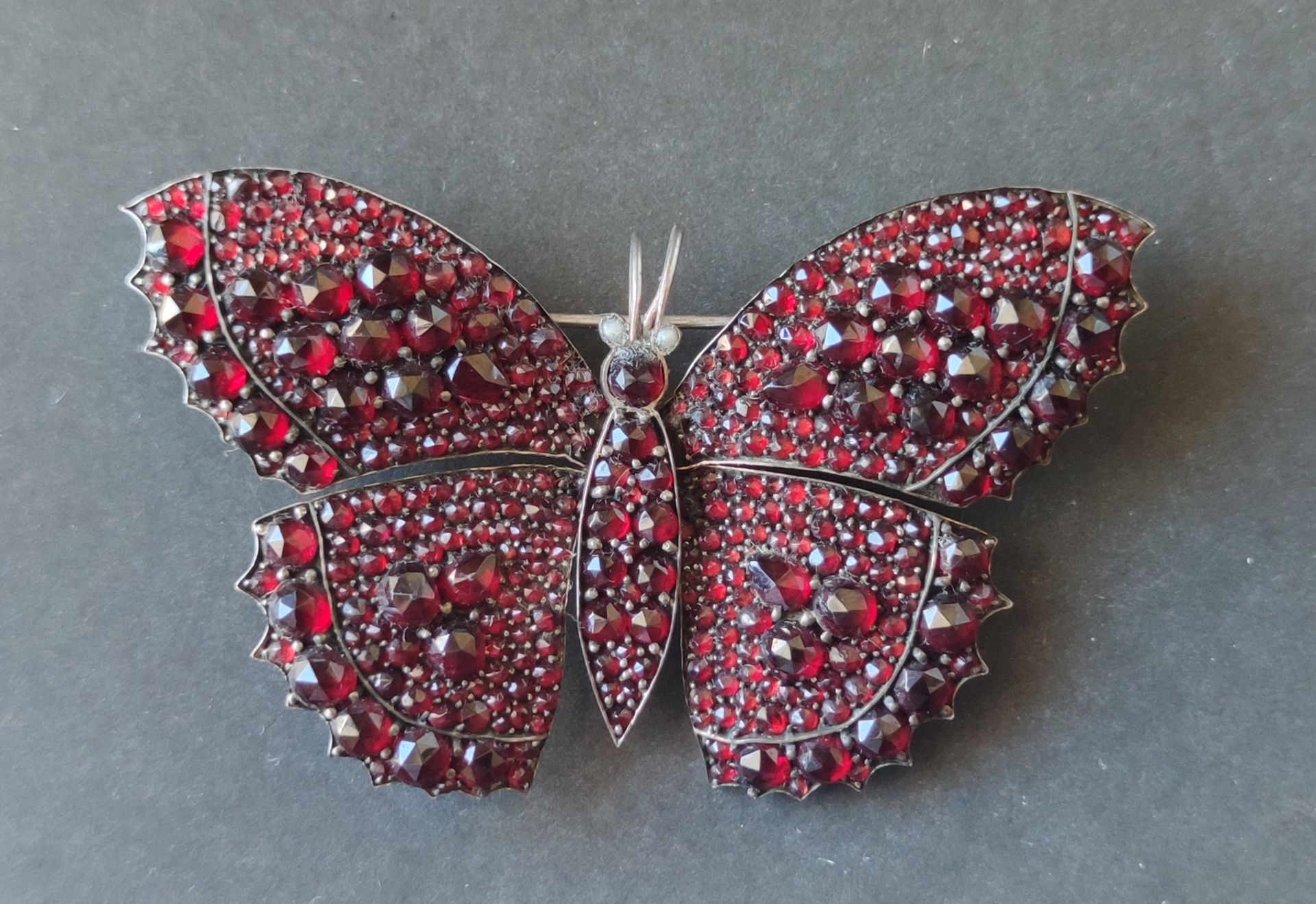 Null 白色或银色金属和石榴石或代表蝴蝶的红色玻璃制品