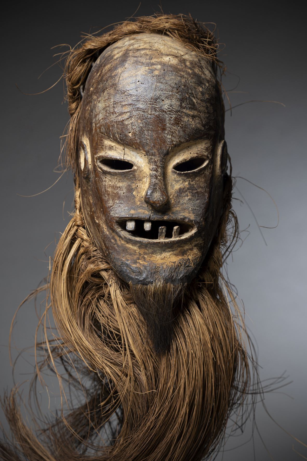 Null BAMILEKE (喀麦隆)

可能来自班甘特地区的面部面具。半张的嘴露出了木质的牙齿。重要的头饰和胡须由植物纤维制成。

高度：34厘米