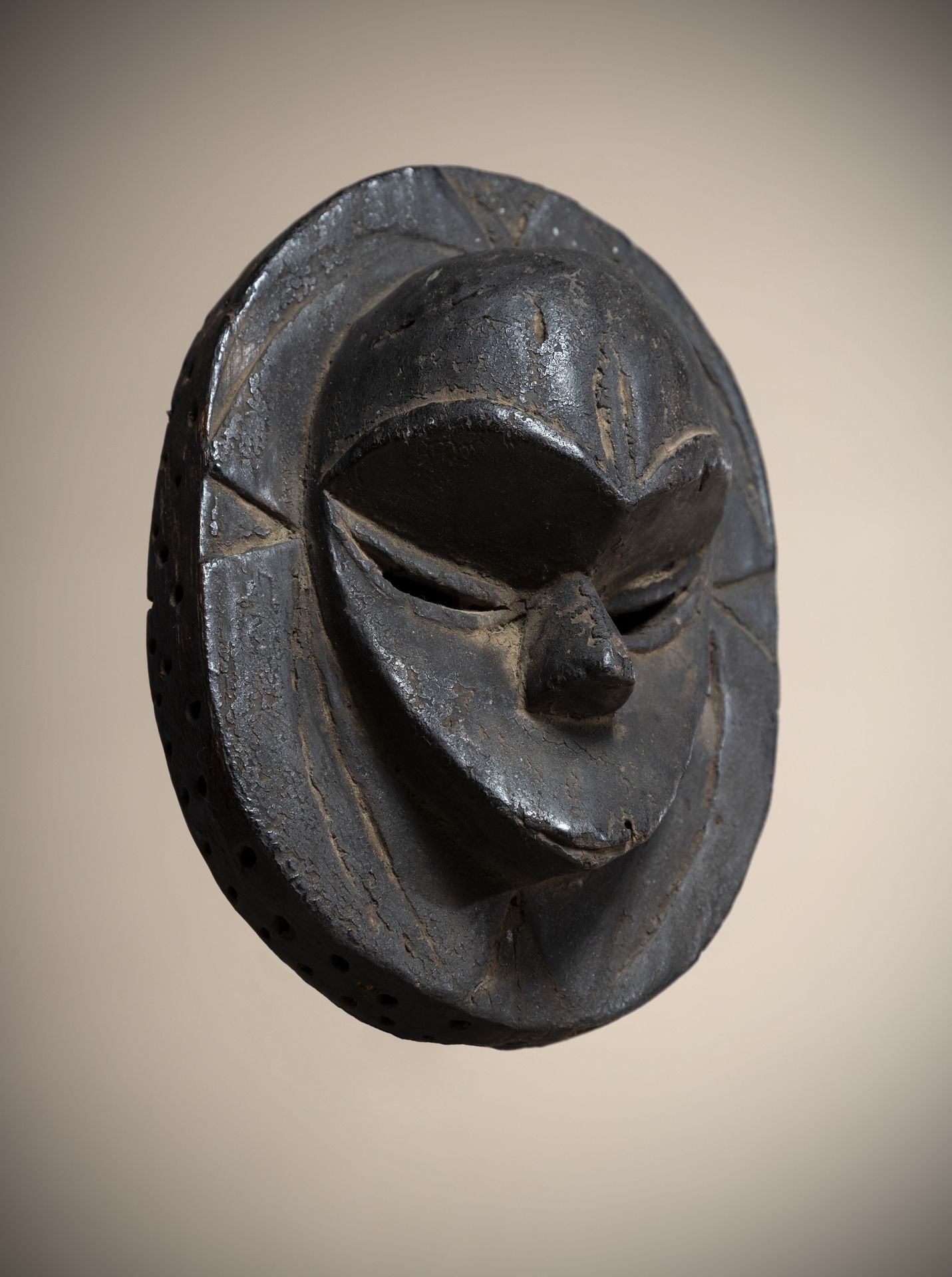 Null EKET (尼日利亚)

带有浮雕面孔的盘状面罩。因使用而产生的深黑色铜锈

高度：17厘米